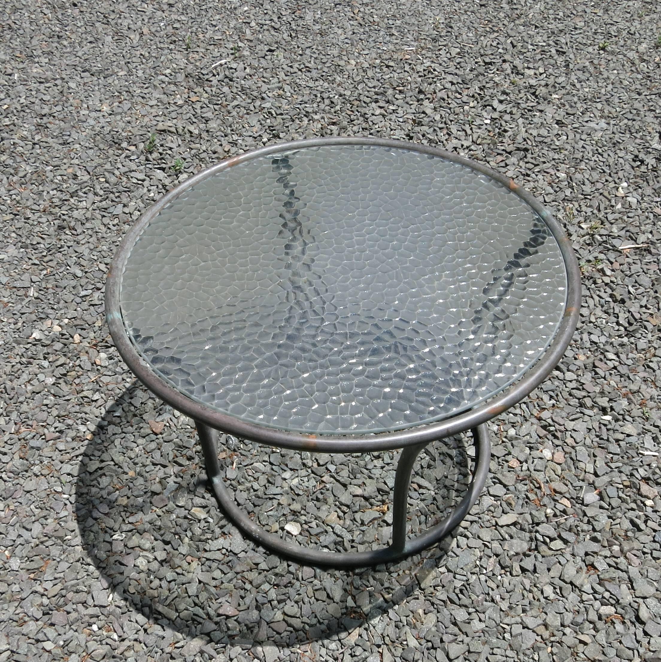 For sale is a Kipp Stewart designed tubular bronze side table for Terra. Excellent condition with original pebble glass top. Measures: 24 1/2