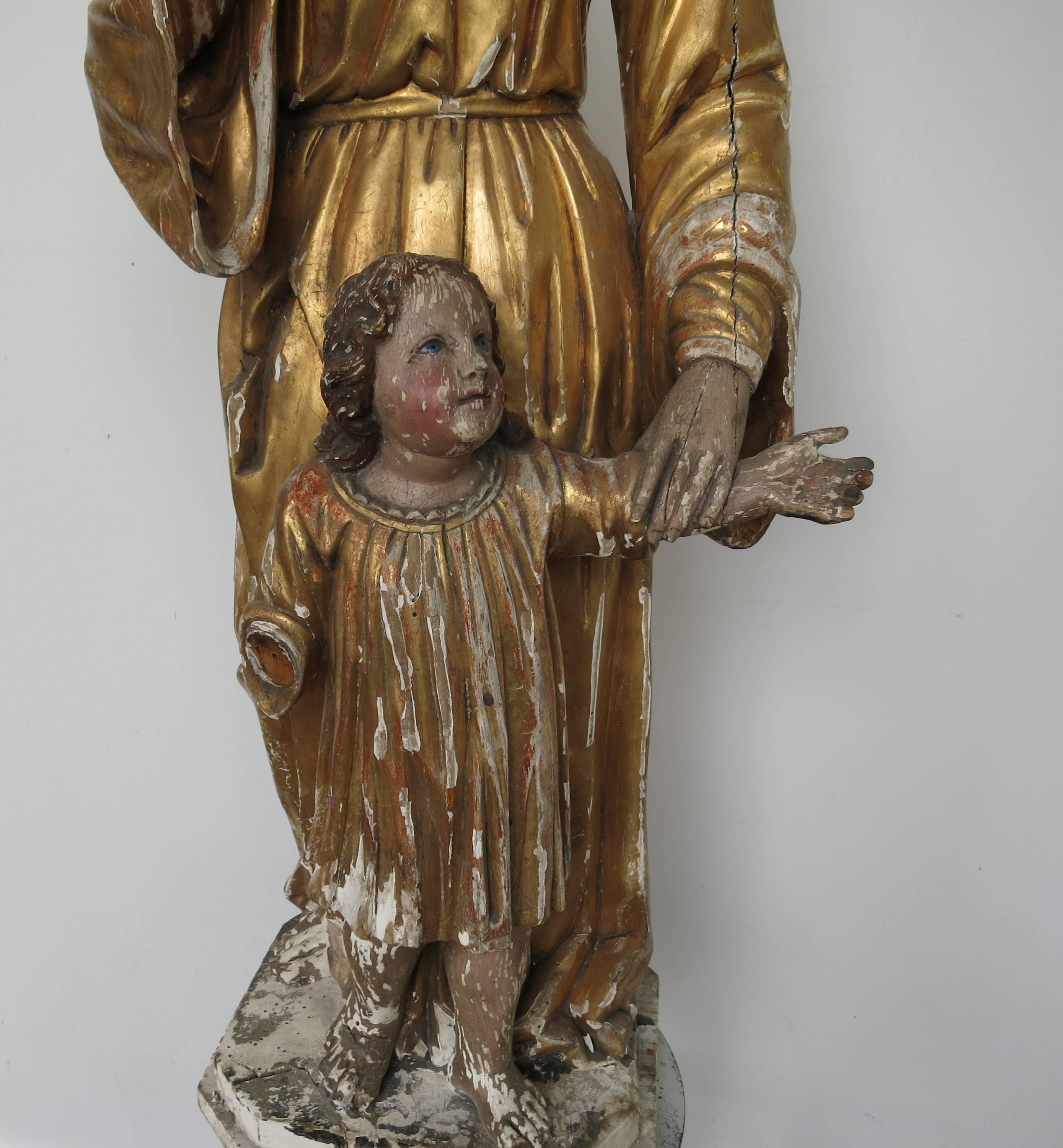 Carved and gilded European statue, possibly French from the 19th century. Distressed and missing its wings. Measure: It stands 37