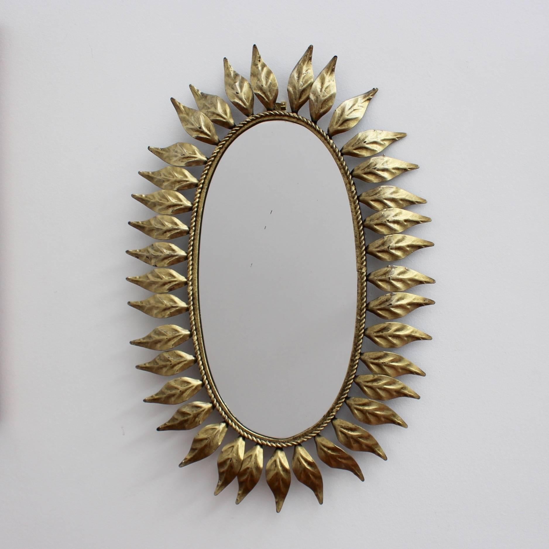 Spanish gilt metal sunburst mirror, circa 1960s with leaf motif rays and rope-pattern mirror border. In excellent vintage condition commensurate with age and use. 

Dimensions frame:

H 57 cm

W 38 cm

Dimensions mirror:

H 38 cm

W 19