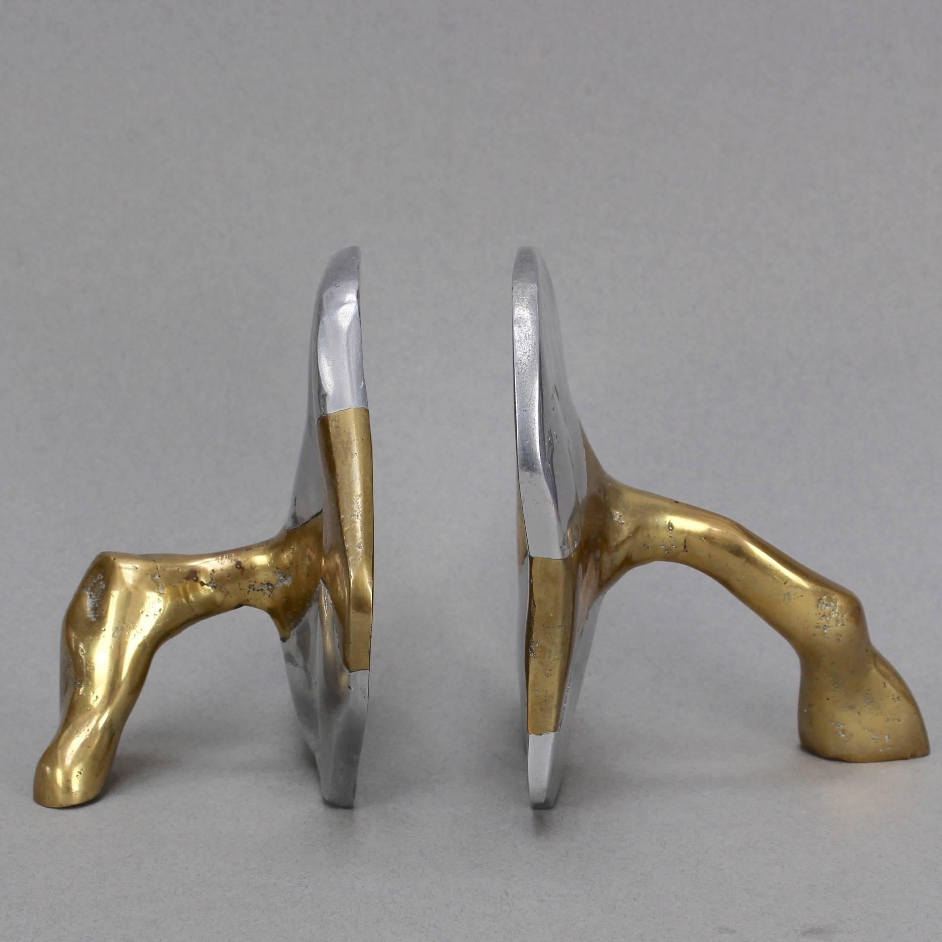 Brass and aluminium Brutalist style bookends by David Marshall, circa 1970s. These are weighty, cratered and raw as if plucked right from nature. The brass support pieces meld with the aluminium seamlessly to form the bookends. Standing alone, these