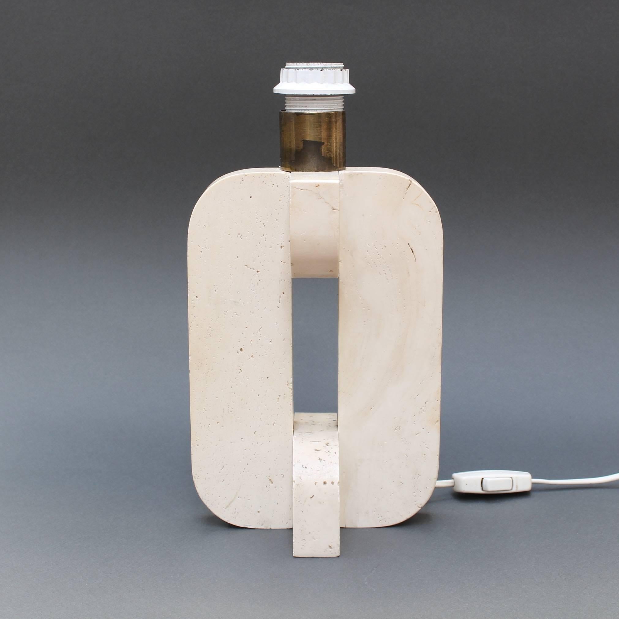 Classic Italian Travertine table lamp (c. 1960s) with flattened oval body and structural geometric cross-sections. Inspired by cubist art, this lamp has a subtle limestone coloured base. Lampshade included. Currently wired for European usage.