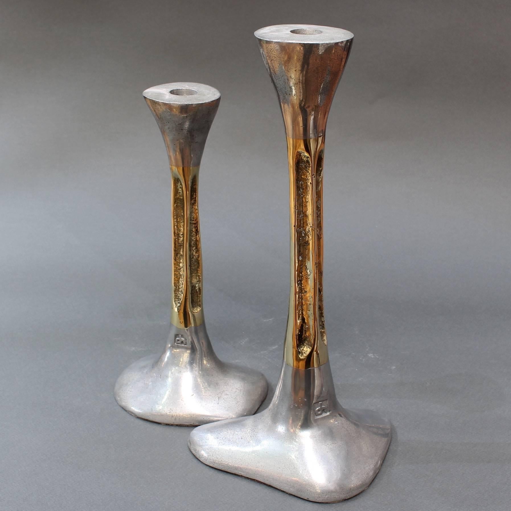 Pair of brutalist aluminium and brass candlesticks by David Marshall, circa 1980s. These brutalist style candlesticks are both weighty and tactile with the maker's mark impressed on the surface near the base. The bottom of the aluminium bases have