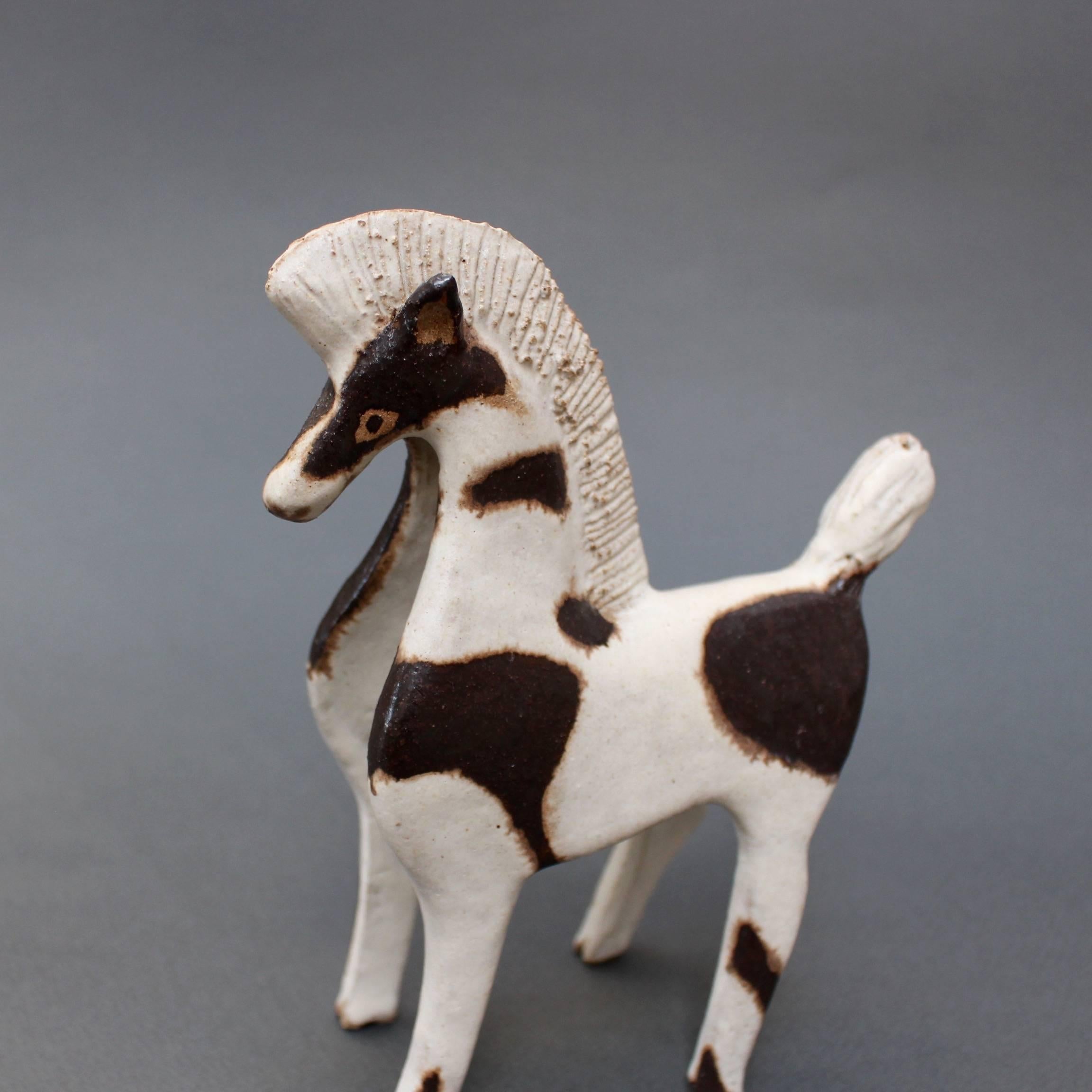 Ceramic two-toned horse by ceramicist Bruno Gambone, (circa 1970s). A charming ceramic parade horse with groomed mane and tail in Gambone's signature chalk-white glaze. The glaze is beautifully complemented by chocolate-brown markings on the horse's