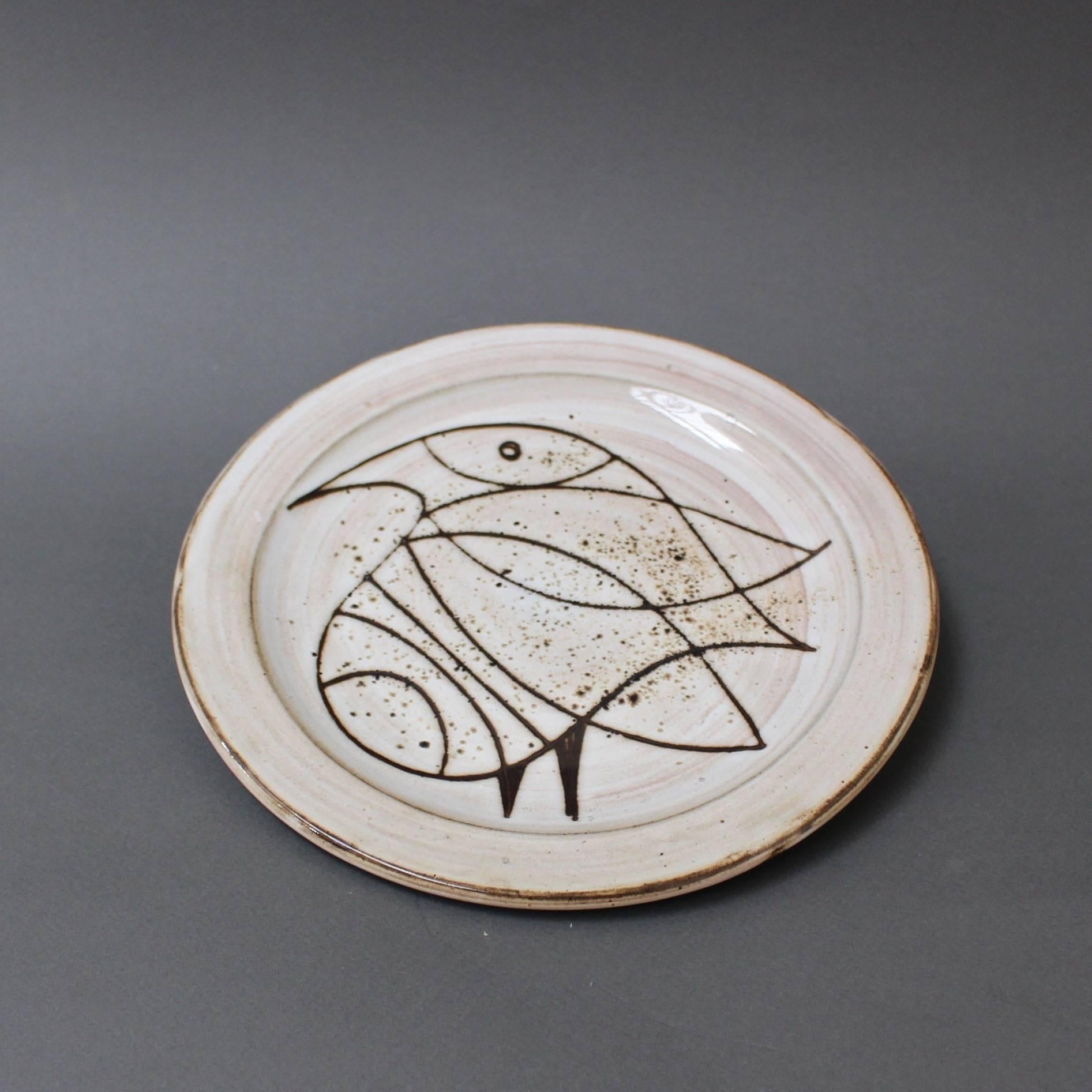This plate (circa 1950s) with large stylised bird, perhaps a lovely dove, is a more personal piece by Pouchain. Pouchain's trademark hazy beige glaze contrasts with the darker brown from the etched bird in the centre of the plate and the outer edge.