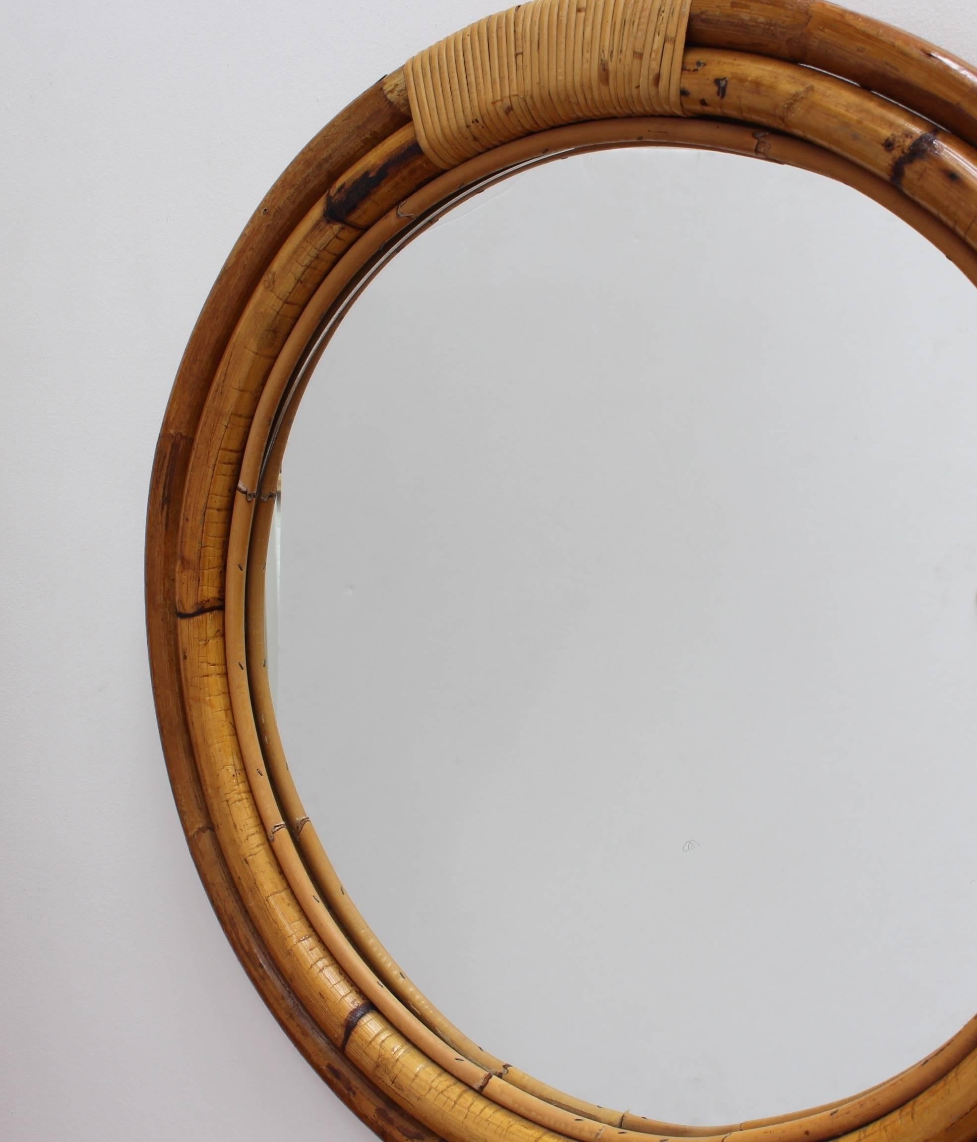 Italian 'porthole' style bamboo and rattan wall mirror circa 1960s. Three concentric tubular rounds of both bamboo and rattan form the structural frame for this porthole mirror with bands of binding rattan. There is a graceful, aged patina on the