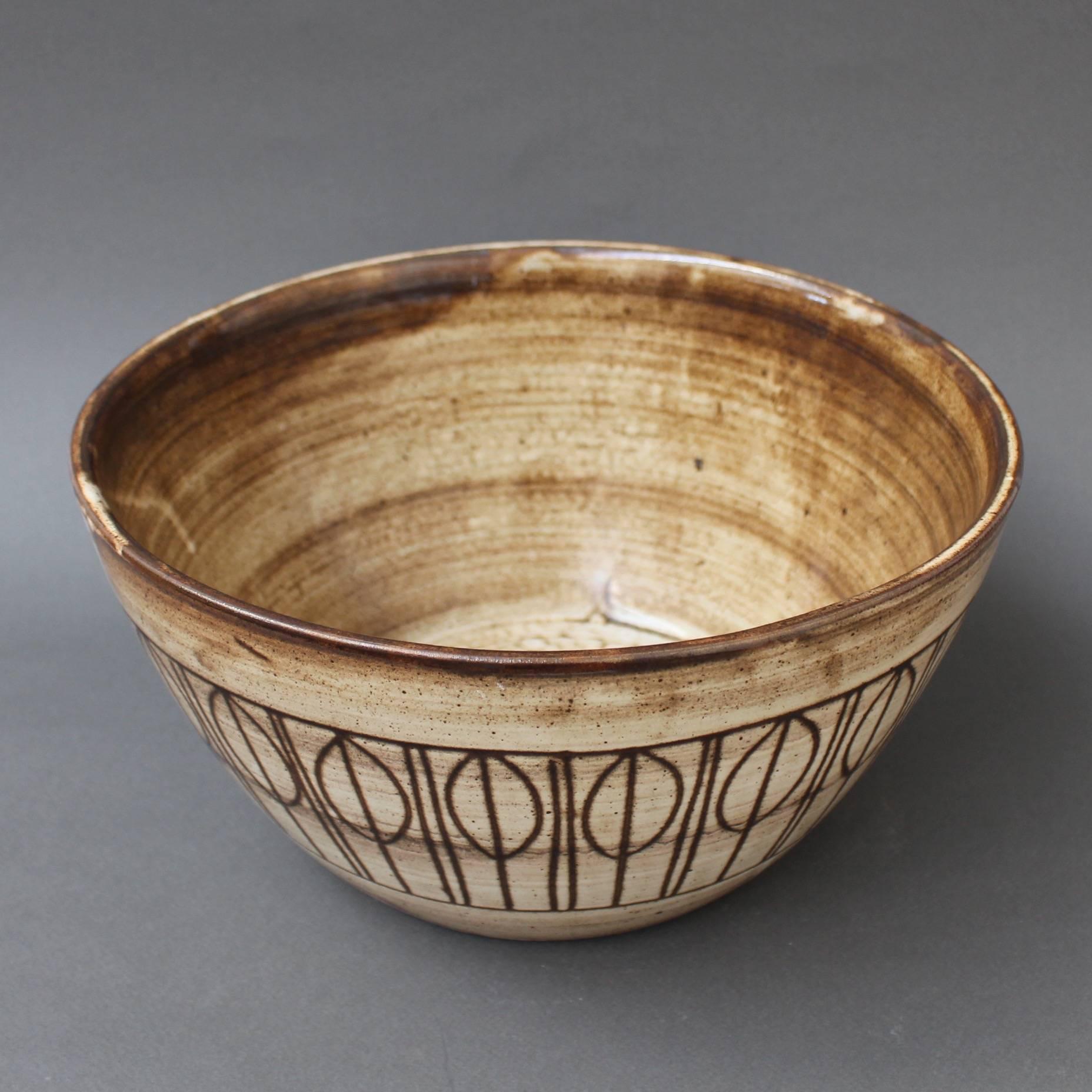 Midcentury decorative bowl, circa 1960s by Jacques Pouchain, Atelier Dieulefit. This decorative bowl was created in Pouchain's trademark tones of brown. The inner bowl may remind one of the rings of Saturn and the drip effects, shooting stars. The