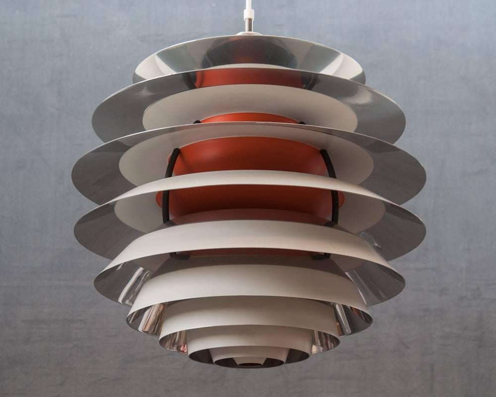 Contrast pendant in painted metal, designed in 1958 by Poul Henningsen and made by Louis Poulsen, Denmark
Painted white metal frame, aluminium leaves, painted white and orange. Measures: ø45 cm.