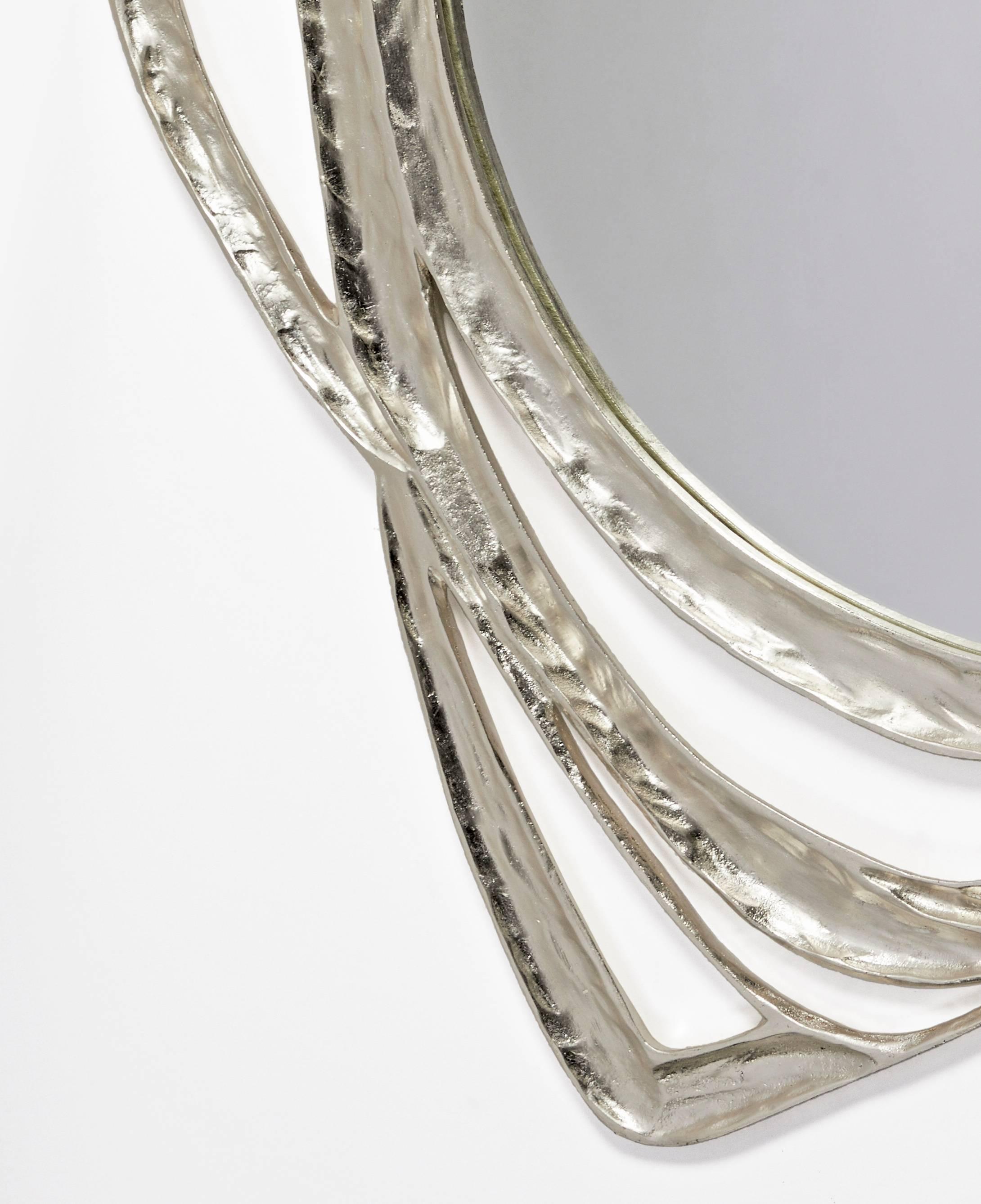 A large mirror in bronze with a white gold leaf finish.