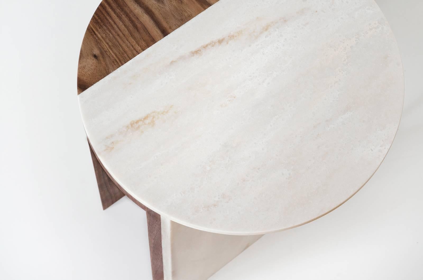 The Gibbous side table pairs wood and solid surface to create a complex and striking Silhouette. The table uses essential elements like the circle, volume, and line in surprising ways, creating a sense of movement through the piece. Lacquered