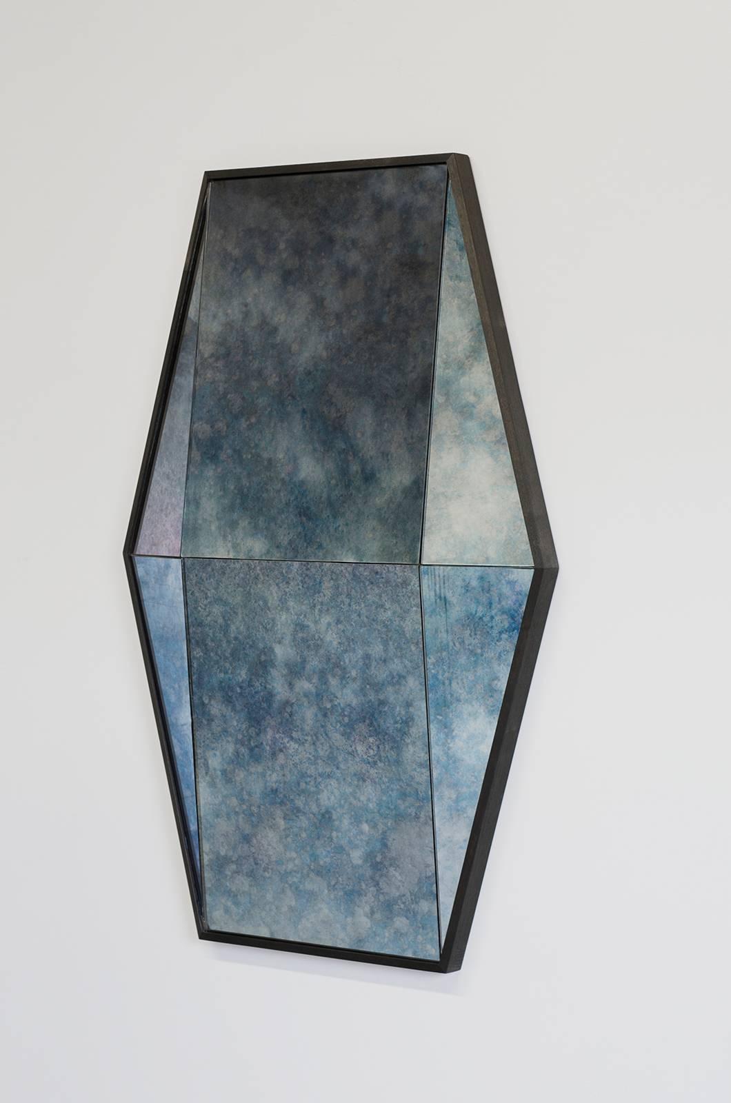 The Gem mirror is built in antique cobalt blue mirror glass, with an ebonized walnut frame.

Built in colored mirror with a hardwood frame, the Gem mirror offers a bold reflective surface. Six faceted panes of glass are a trick to the eye - walk