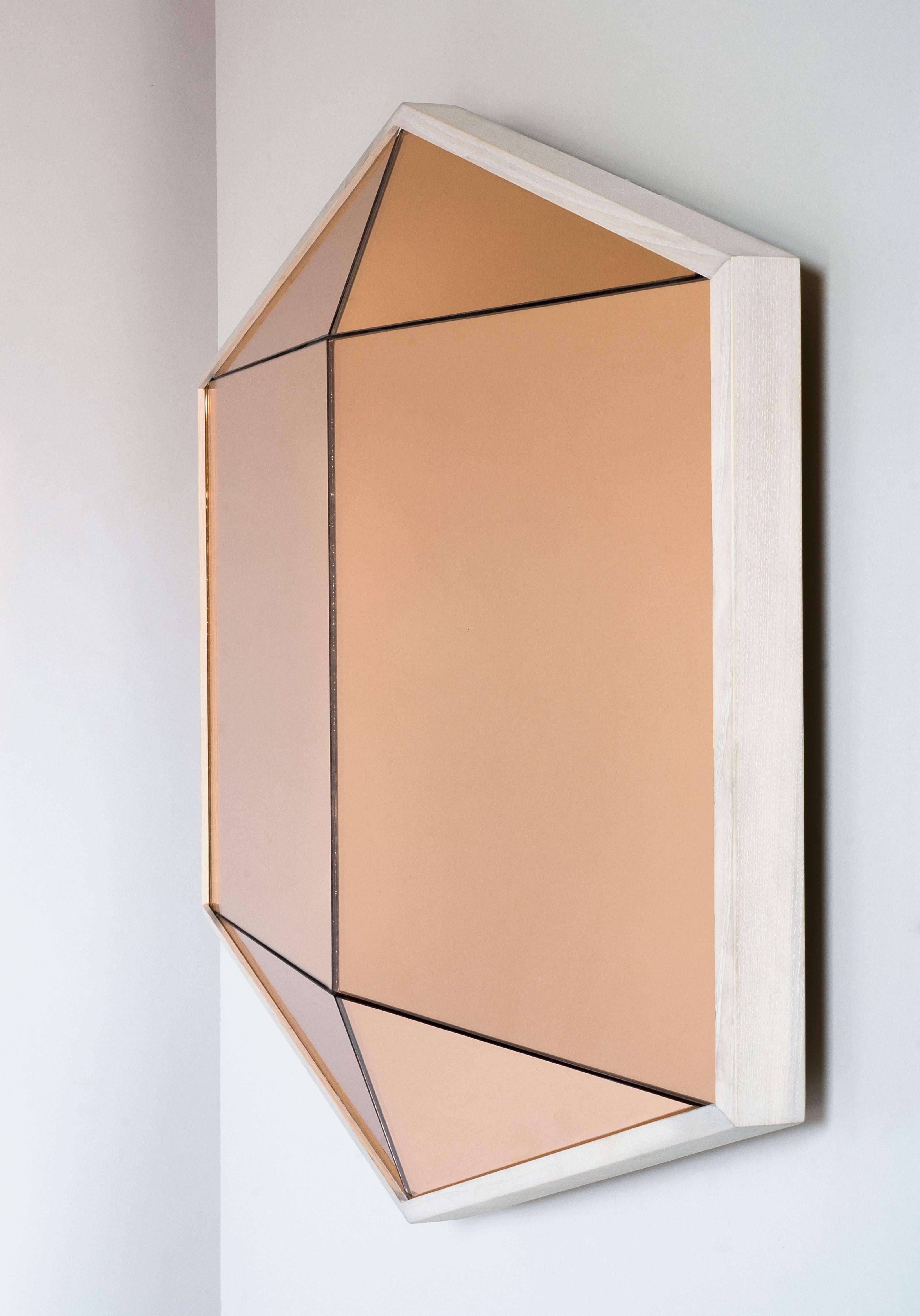 Built in colored mirror with a hardwood frame, the Gem mirror offers a bold reflective surface. Six faceted panes of glass are a trick to the eye walk past and one's reflection seems to appear and disappear. 

The gem mirror was featured in the