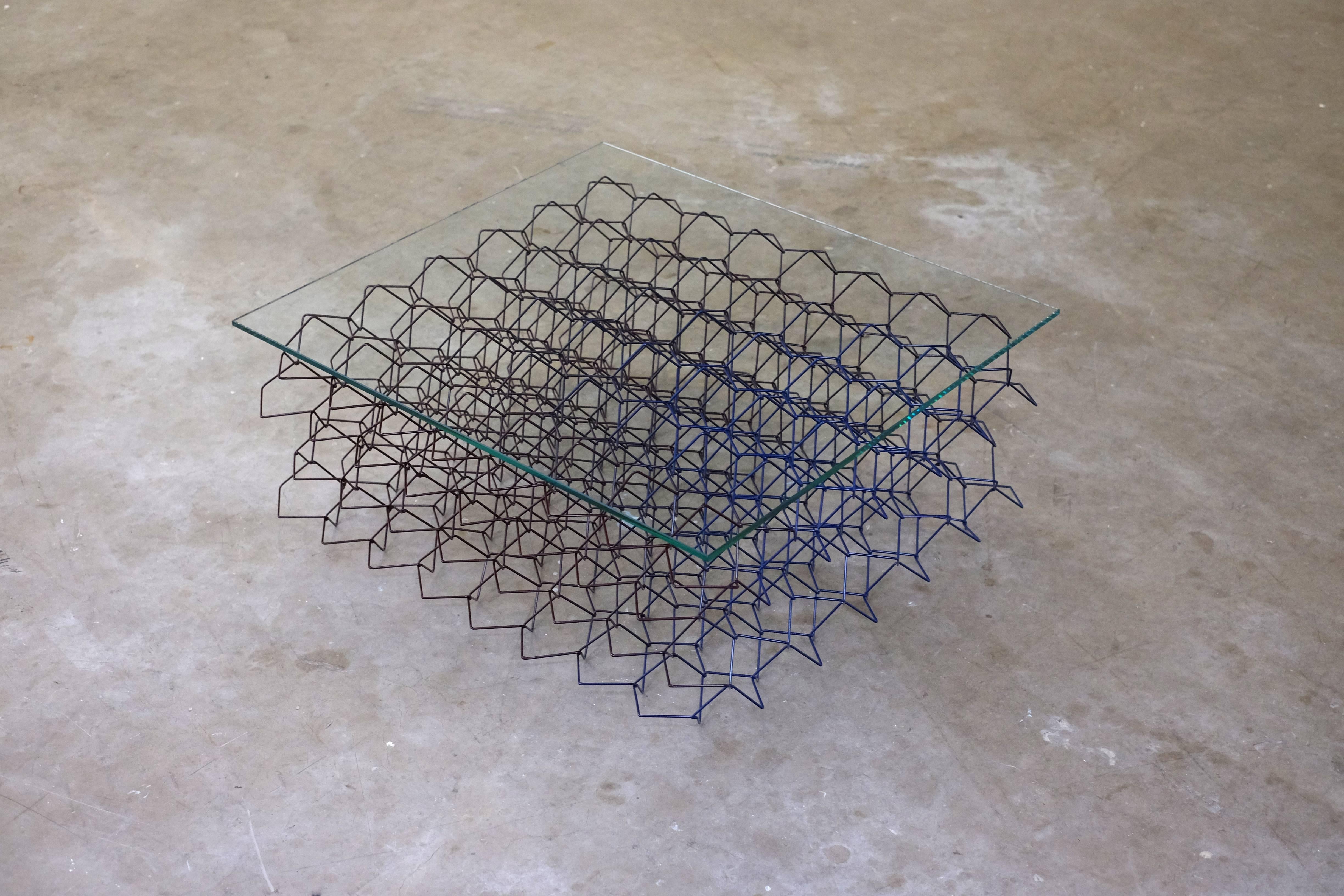 The seismic coffee table was inspired by the movement and vibrations that occur in an earthquake. Three-dimensional bent and woven metal wires create a strong and dynamic structure. A range of rhythmic and geometric patterns can be discovered, when