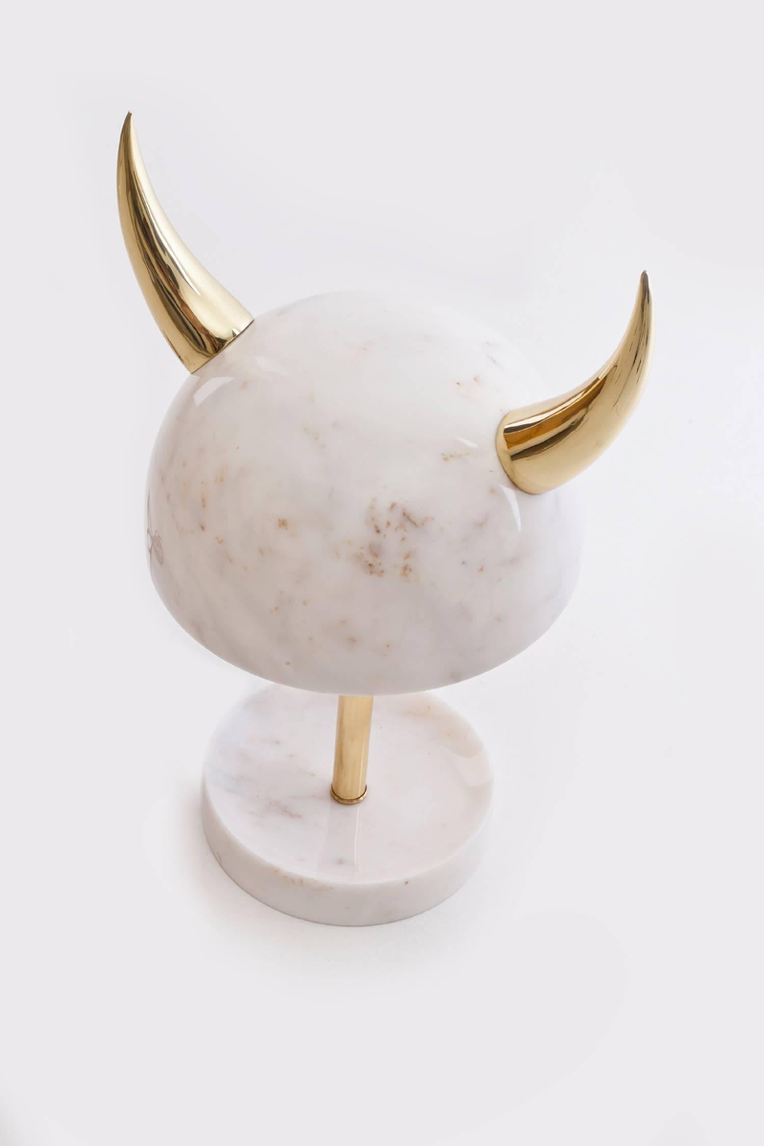 My little Viking table lamp pays homage to old Scandinavian warrior helmets. It echoes the shape and style with a contemporary twist. The metallic armour and bone have been replaced by marble and polished brass, giving this barbaric symbol an