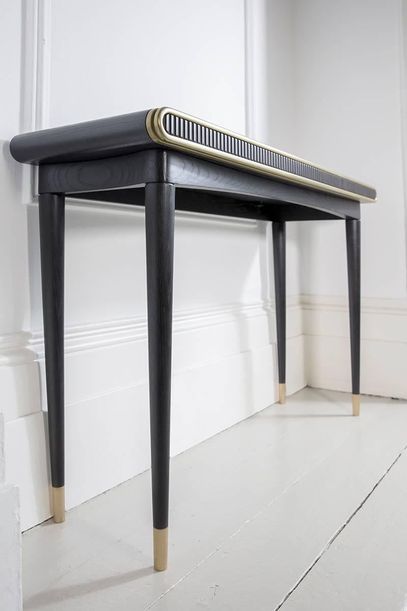 A distinctive console table that uses both liquid & solid brass, blackened oak & corian to create the perfect piece for any interior.

MATERIALS
• Blackened oak
• Solid and liquid brass 
• Corian

DIMENSIONS:
Height 80cm x Depth 35cm x Width 120cm