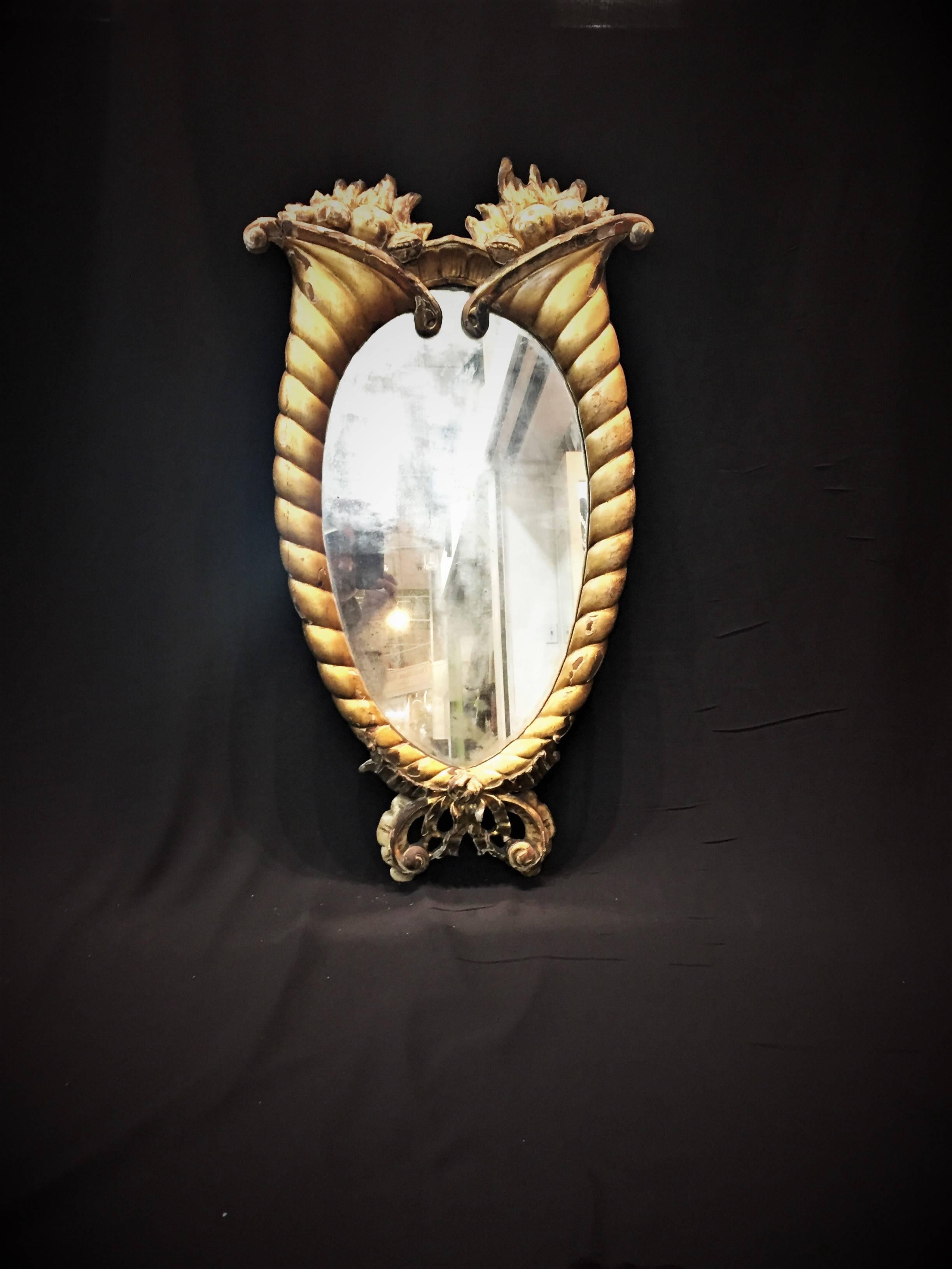 This small and very unusual wall mirror has most non-trivial design in the playful style of La Belle Époque. In all likelihood, it hung in the foyer of some elegant Paris apartment sometime in the last quarter of the 19th century. The hand-carved