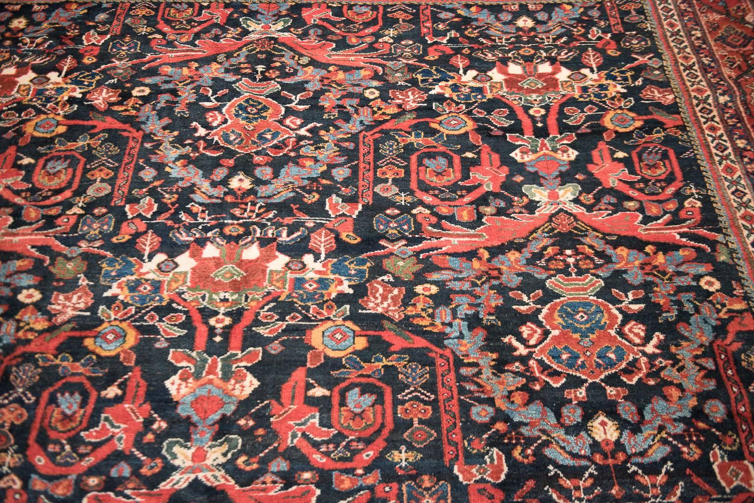 This antique Mahal carpet is so bold in crimson and navy that it is practically twisting free from its knots, stretching its weft and weave to fill every last inch of its 11’ by 16’ with its intricate all-over design. The Mahal featires an all-over