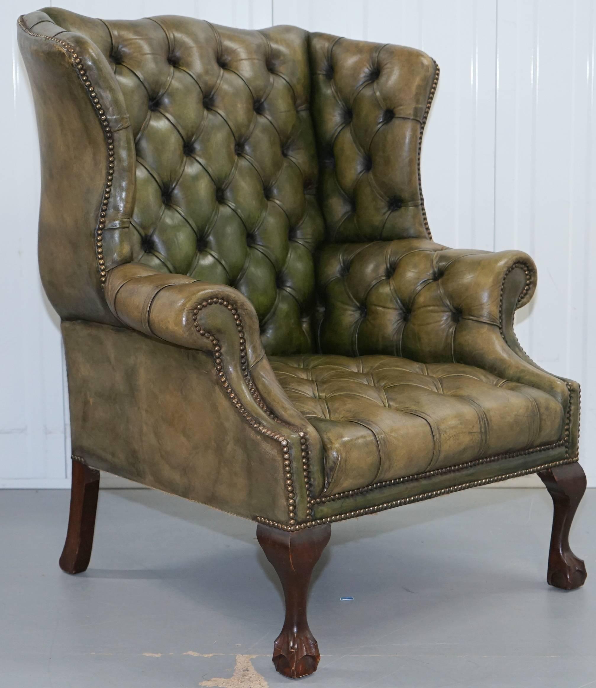 We are delighted to offer for sale this lovely original 1960s hand dyed green leather Chesterfield wingback armchair with George III straight H-frame legs and a matching fully buttoned wingback armchair with hand-carved claw and ball feet 

Please