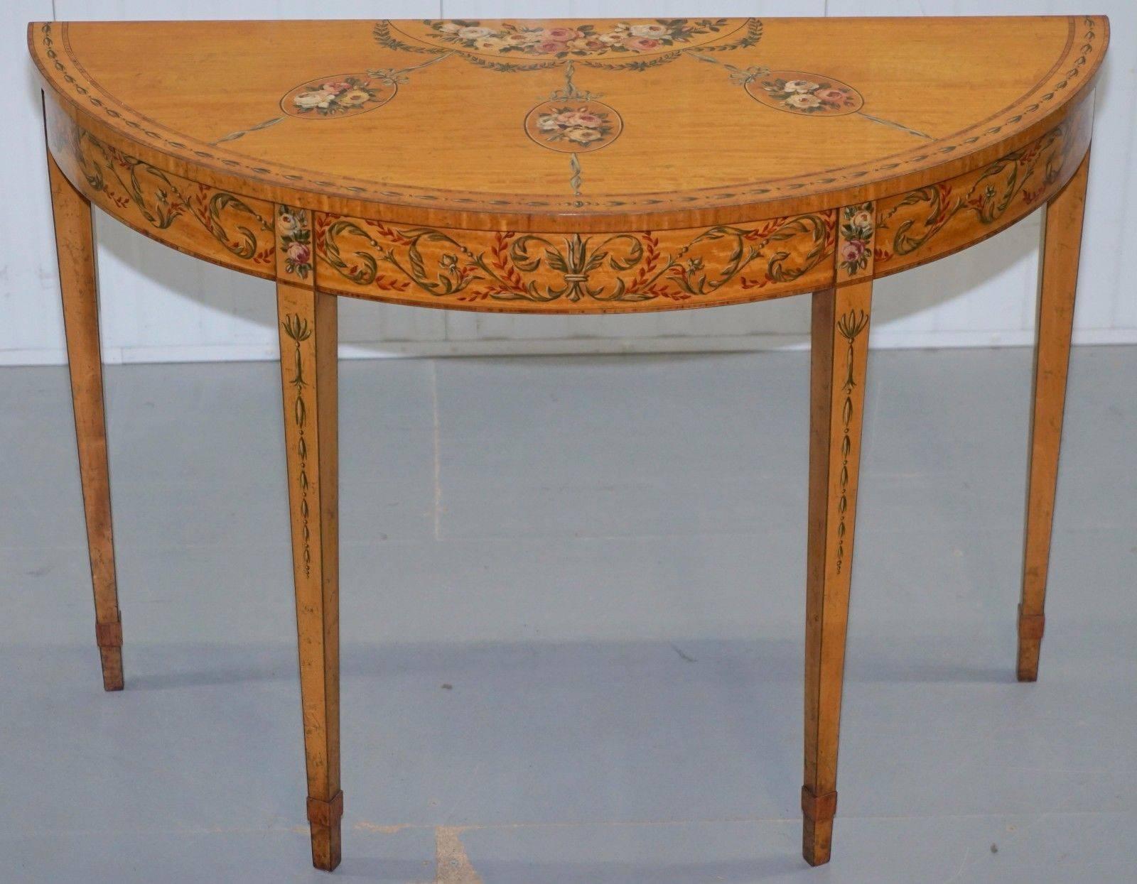 We are delighted to offer for sale this lovely hand-painted satinwood Sheraton revival late Victorian demilune console table

A truly stunning piece in exquisite condition throughout, the hand-painted floral motifs are absolutely faultless and