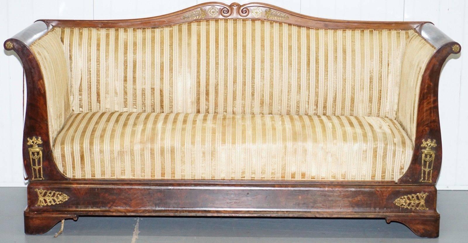 We are delighted to offer for sale this Biedermeier gilt metal mounted scroll arm mahogany framed sofa in the French Empire taste
 
A truly stunning piece, this sofa looks amazing from every single angle, the mahogany patina and gilt fittings