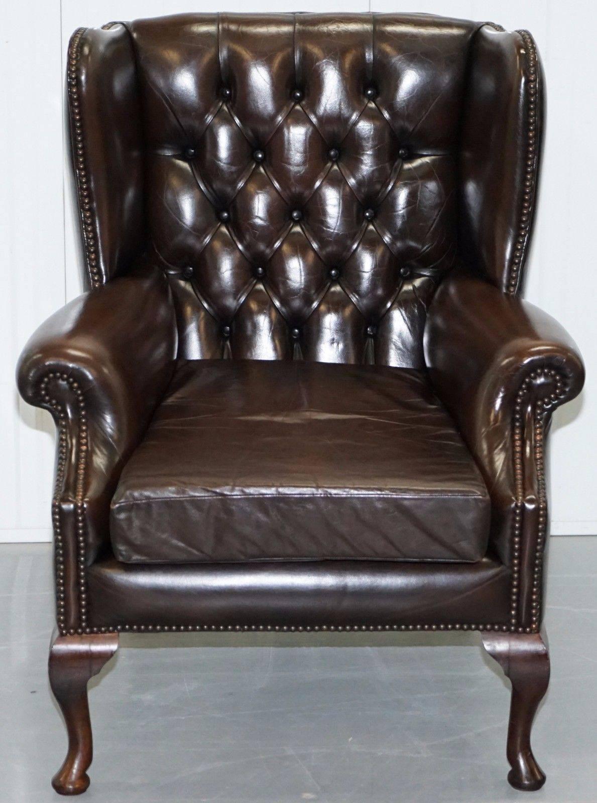 British Pair of 1960s Aged Brown Leather Chesterfield Wingback Armchairs and Footstool