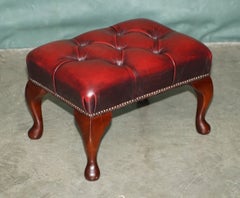 SUPERBE REPOSE-PIEDS DE STYLE ANTIQUE, EN CUIR COULEUR SANG DE BOEUF, À BOUTONS PROFONDS, AVEC FINITION EN BOIS MASSIF