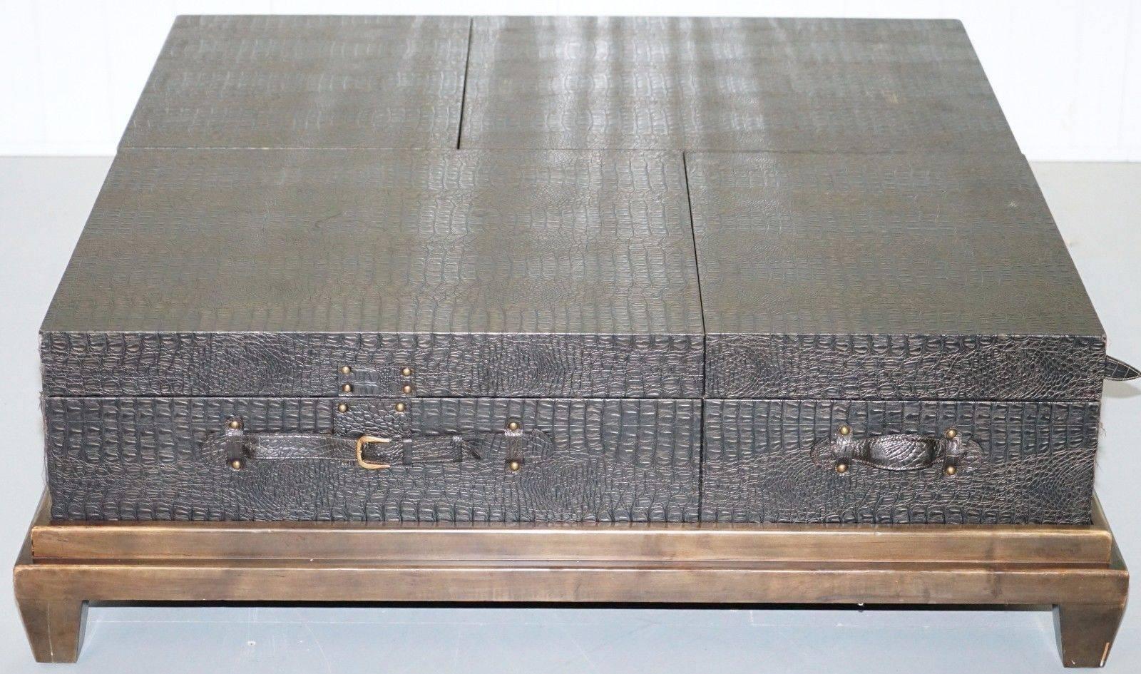 We are delighted to offer for sale this lovely huge 130cm square metamorphic coffee table with hidden drawers upholstered with faux alligator skin and styled around luggage

Please note the delivery fee listed is just a guide, for an accurate quote