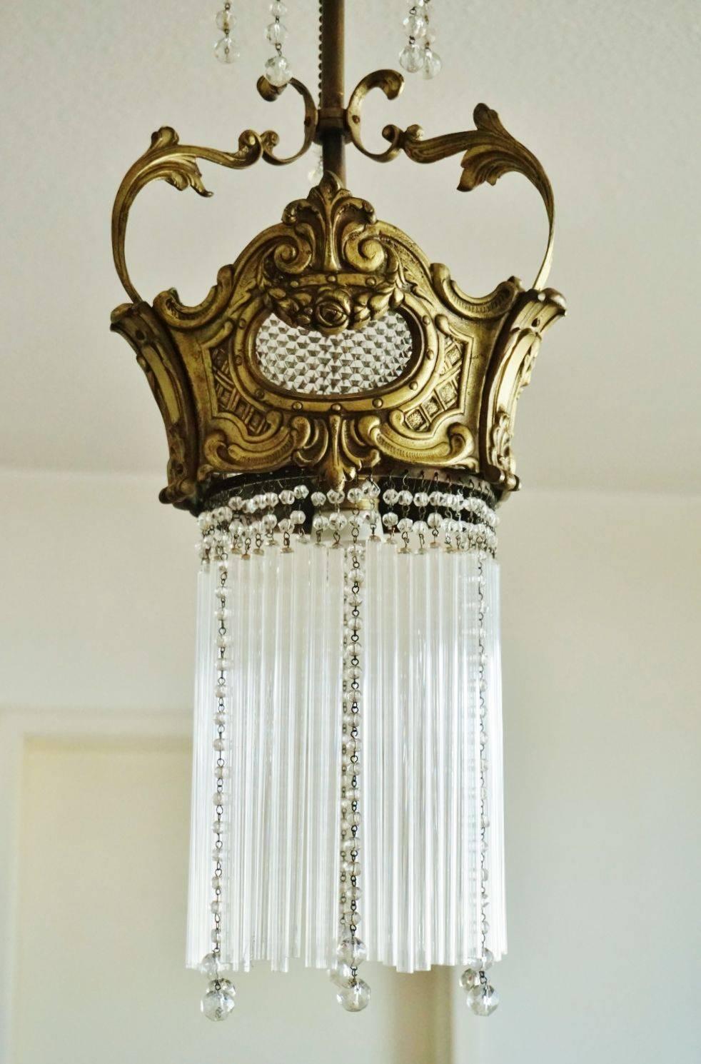 This wonderful Art Nouveau period chandelier is a unique piece, cold cast bronze crone ornate with fine details, long glass rods and crystal hangings, circa 1890.

One large lamp socket 
Measure: Height 35 1/2 in (90 cm)
Diameter 9 1/2 in (24