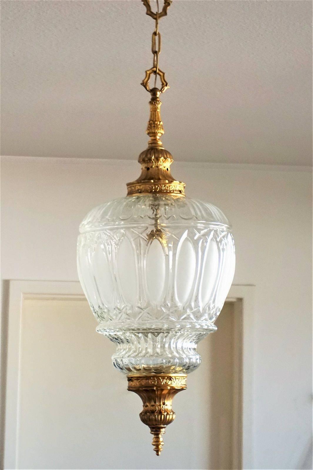 Art Deco cast gilt bronze lantern, pendant with large high relief glass shade, circa 1920. 
One large lamp socket

Measures: Total height: 40 ½ in (103 cm) 
Diameter: 13 ¾ in (35 cm)
Height without chain: 30 in (76 cm)
Glass shade only: D 13 ¾ , H