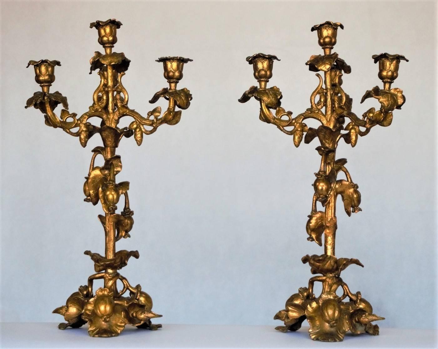 Pair of French gilt art bronze four-light candelabras in Rococo style, richly decorated with fruits and vine.

Measures:
Height 20.50 in (52 cm)
Width/depth 10.75 in (27 cm)
Base 6.75 (17 cm)
  