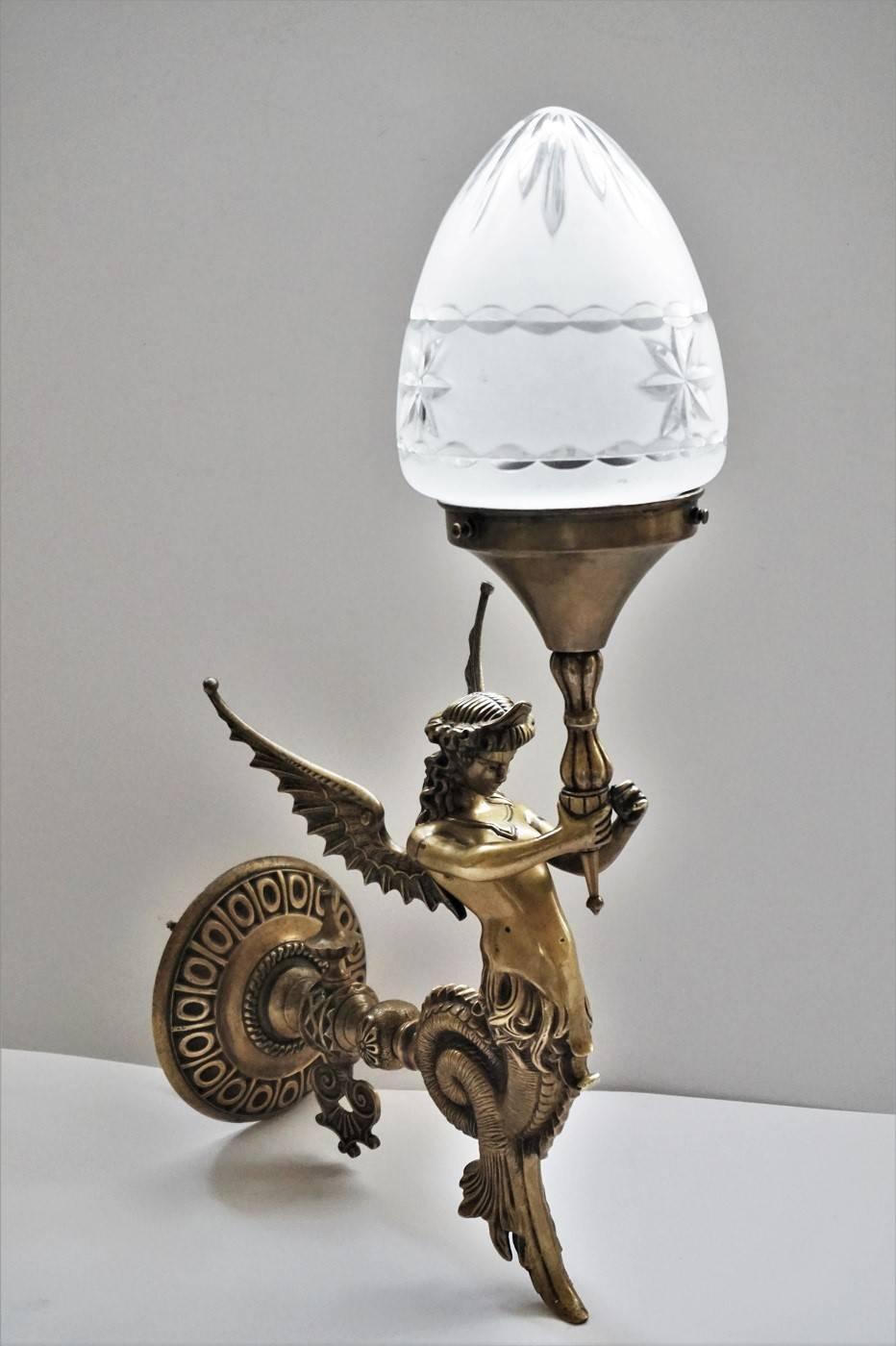 Empire style chased bronze winged figural wall sconce, France, circa 1880-1890, with frosted cut-glass shade. 

This piece has been electrified at a later time: One light socket

Measures: Total height 19 in (48 cm)
Height without shade 13 in
