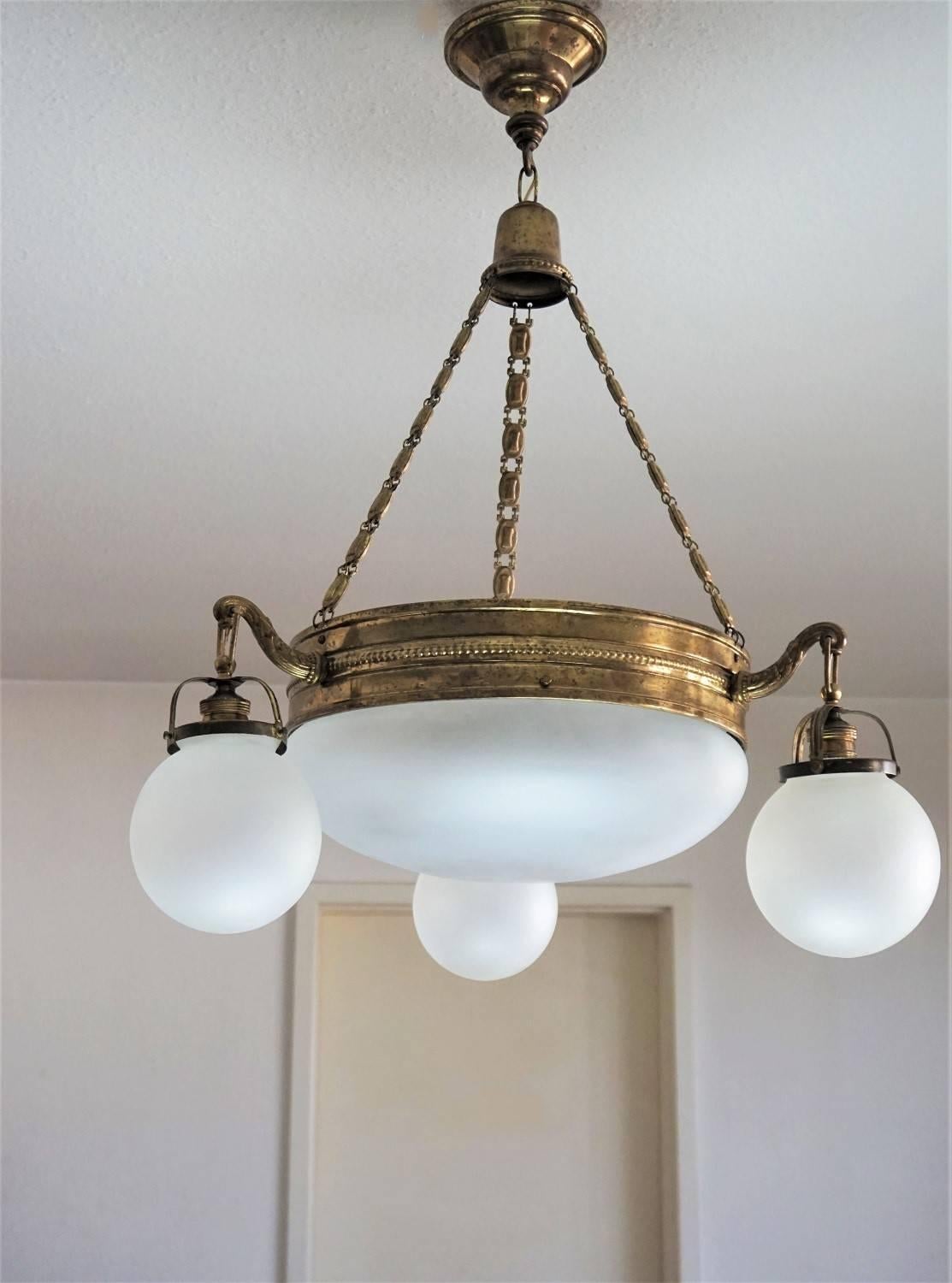 Italian Art Deco brass four-light chandelier frosted glass in original condition, ca. 1920. Large brass disc with bowl shade and thee lamp arms with ball globes.

Four large bulb sockets
Measures:
Height 29.50 in (75 cm)
Diameter 21.50 in (55 cm)

 