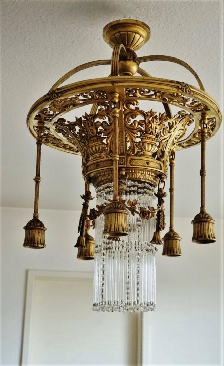 Empire style French crown shaped gild bronze six-light chandelier, richly ornate with floral motifs and decorated with garlands, five-arm surrounding the long glass rods and crystal pearls.
European wiring: Six E27 bulb sockets . Rewired and ready