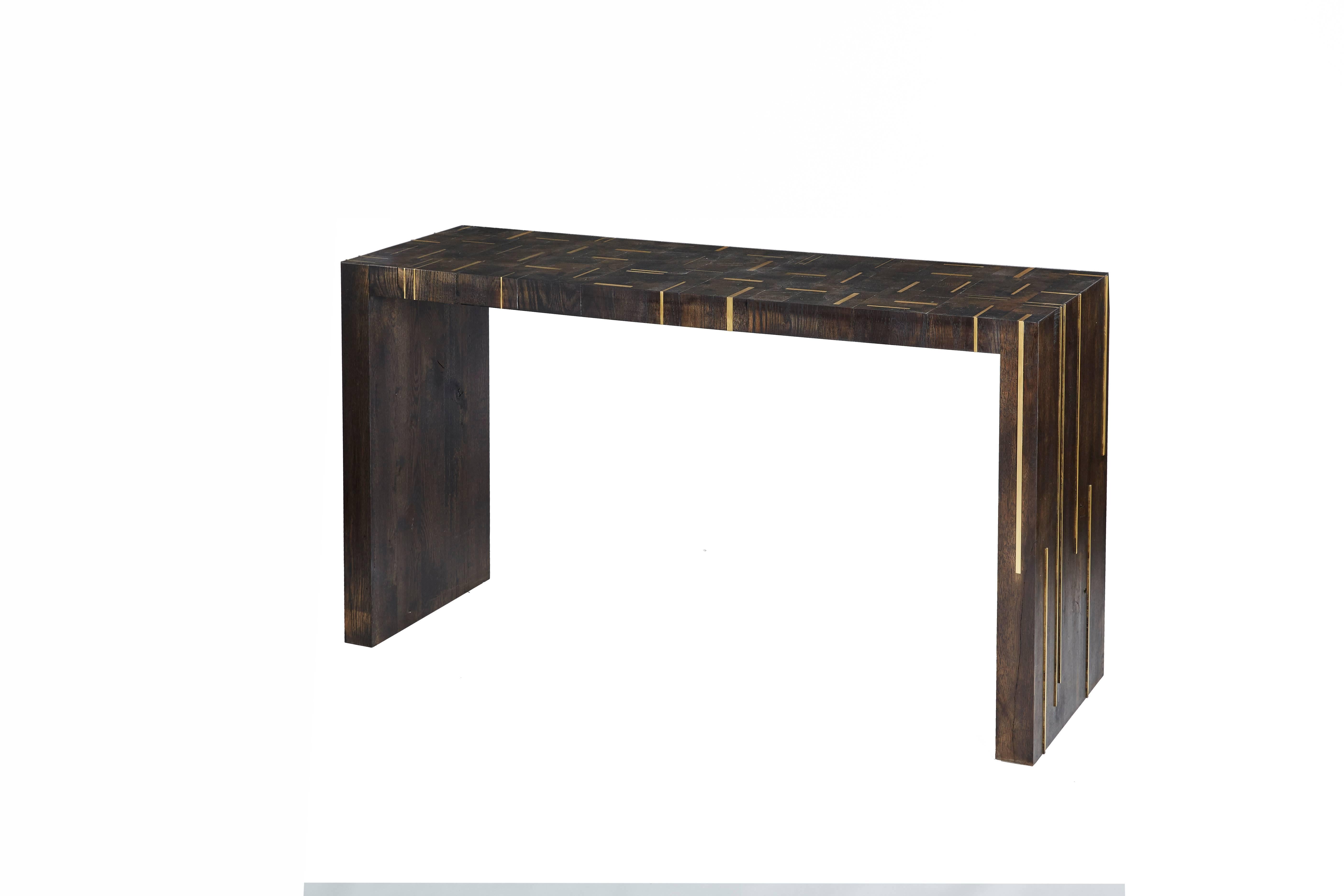 Amuneal’s modern butcher block console table is constructed from white oak endgrain cuts and solid bronze inlays. The finish on these handmade tables is highlighted by wire-brushing and burning the reclaimed endgrain assemblies, once fabricated,