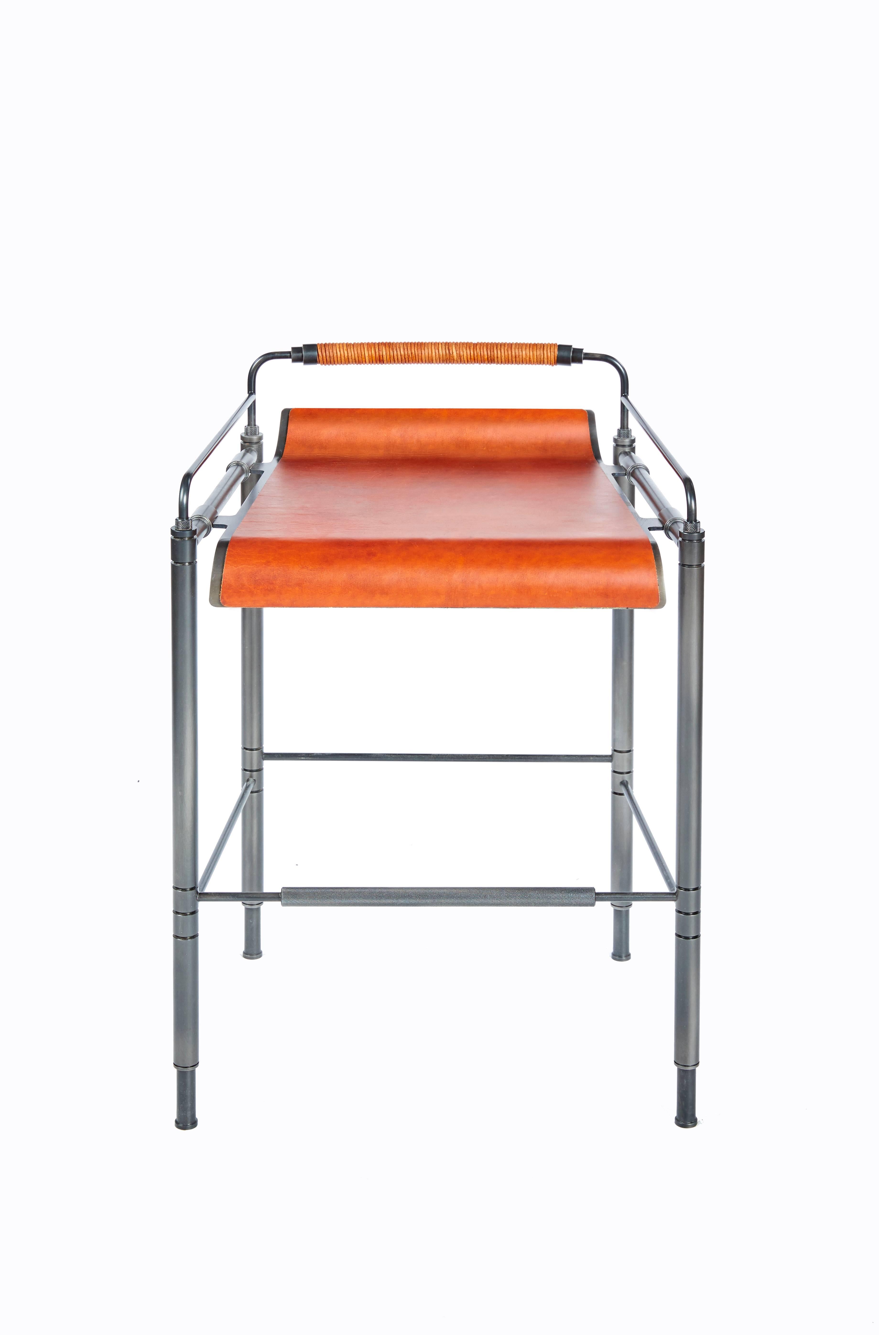 Amuneal’s blackened steel and leather stools are fabricated from precision machined and laser-cut steel components. The laser-cut and formed seat is hand clad in leather and suspended from machined connections. The seat back is hand-wrapped in