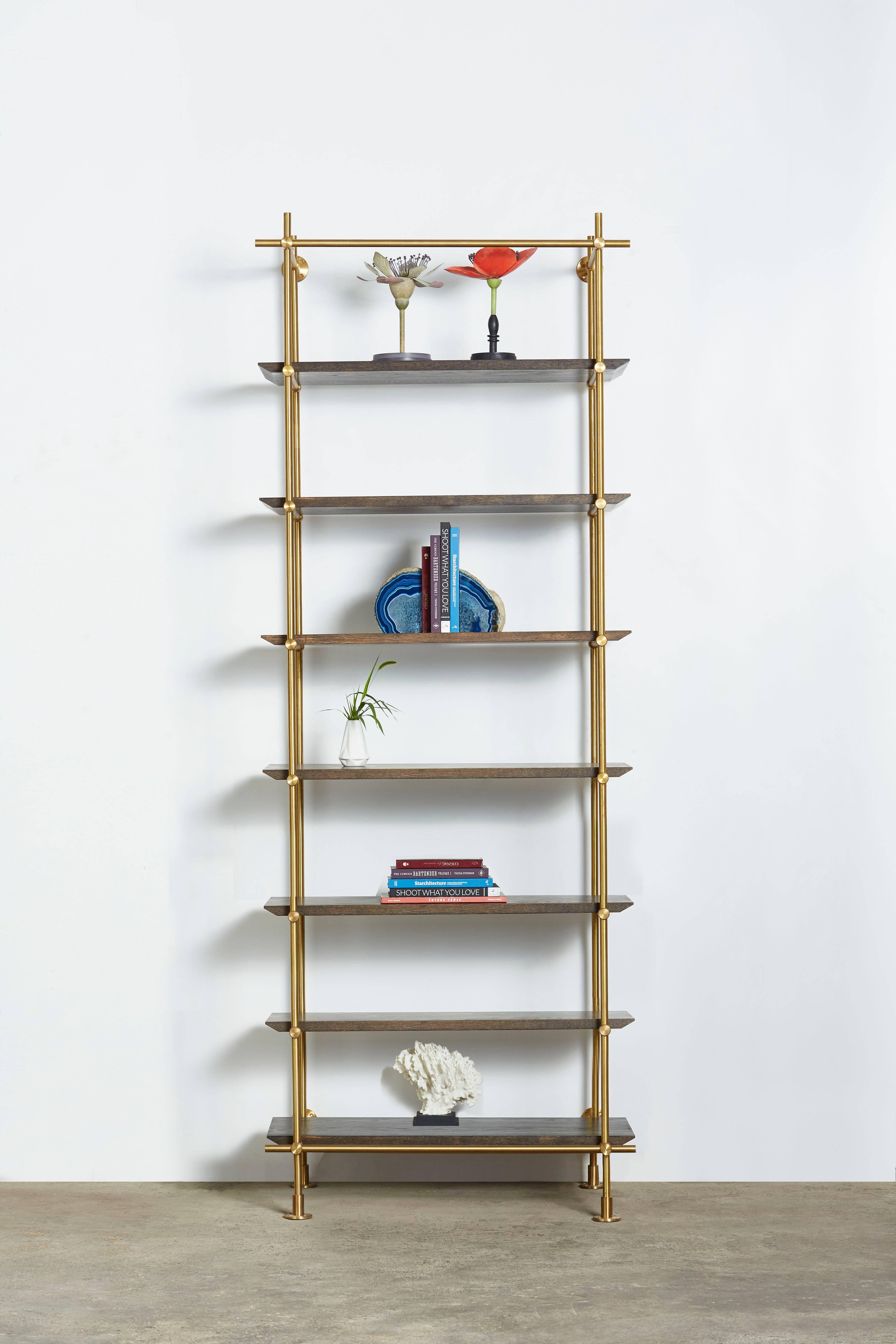 This single bay version of Amuneal’s Collector’s shelving unit features solid machined brass fittings and posts in a warm brass finish. The unit mounts to the floor and to the wall to support a series of easily adjustable solid wood shelves. The