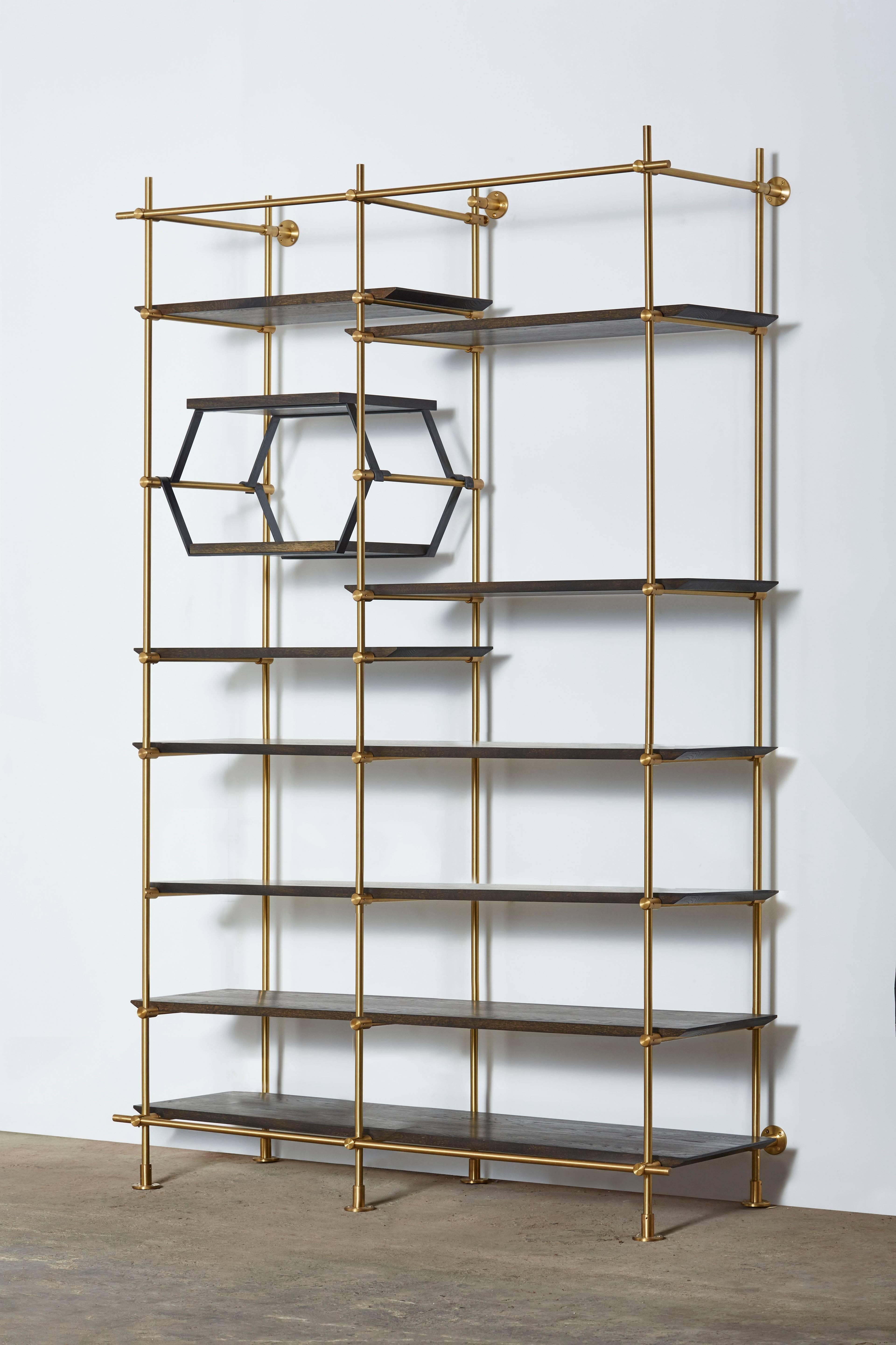 This two-bay version of Amuneal’s collector’s shelving unit features solid machined brass fittings and posts in a warm brass finish. The unit mounts to the floor and to the wall to support a series of easily adjustable shelves. The wood shelves are
