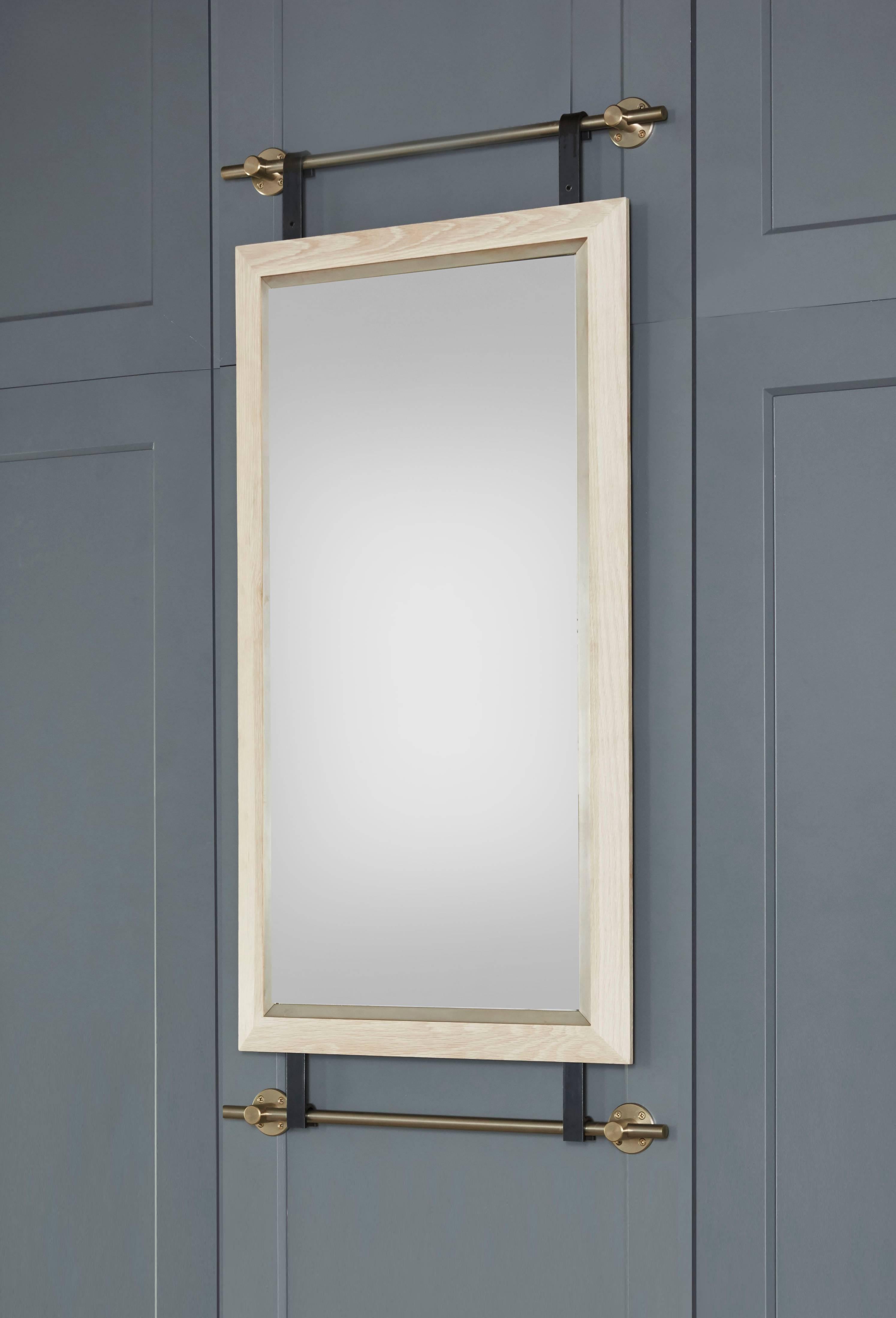 Amuneal’s collector’s shelving hardware is used to support this mirror, framed in bleached oak. The horizontal supports are machined from solid brass and are shown in a champagne brass finish. The mirror is glazed into a bleached white oak frame