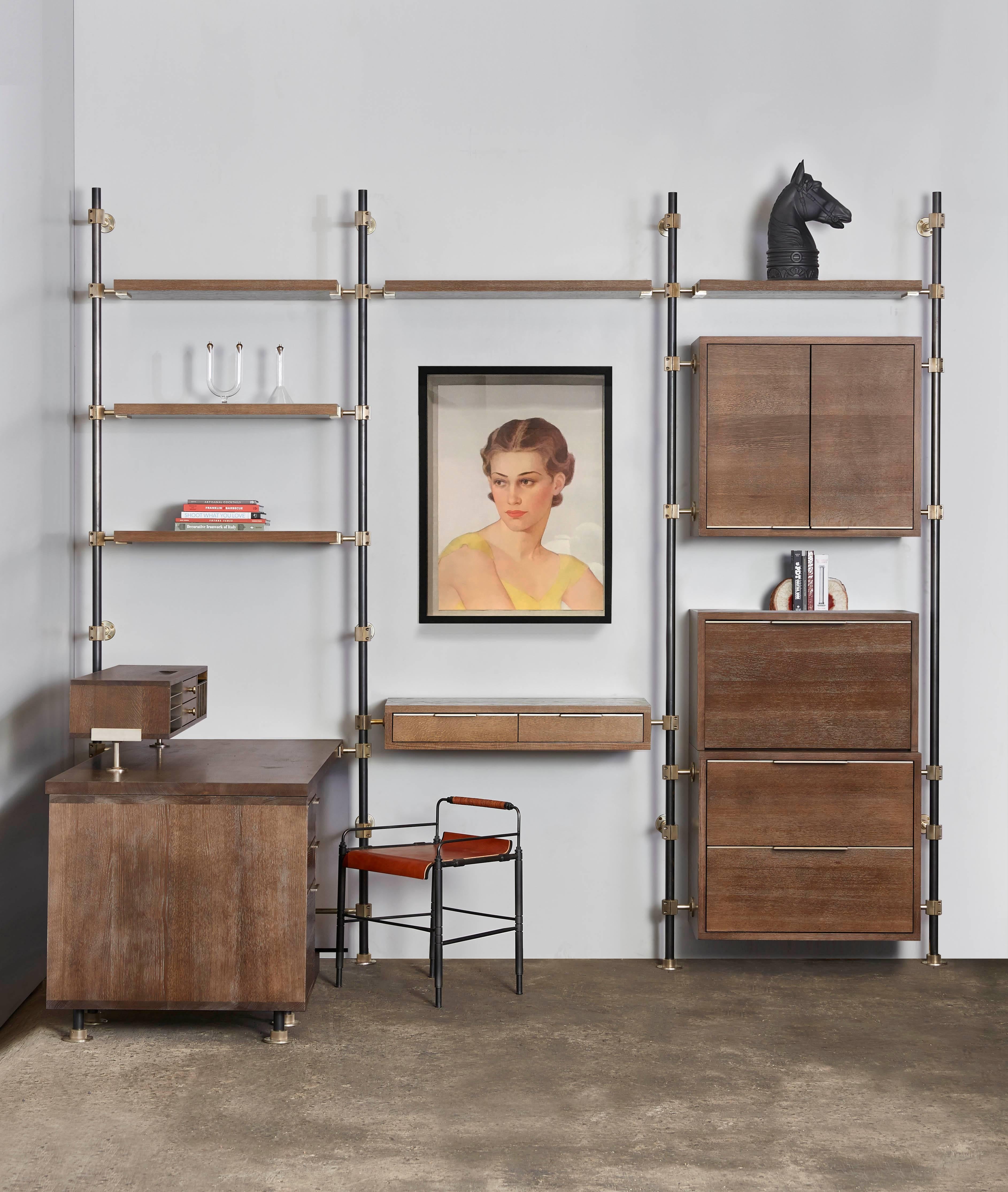 The loft work suite is a modular office system from Amuneal’s Loft shelving system. Posts in blackened steel are coupled with solid brass machined fittings in a champagne finish. The posts mount from floor to wall and the adjustable fittings support