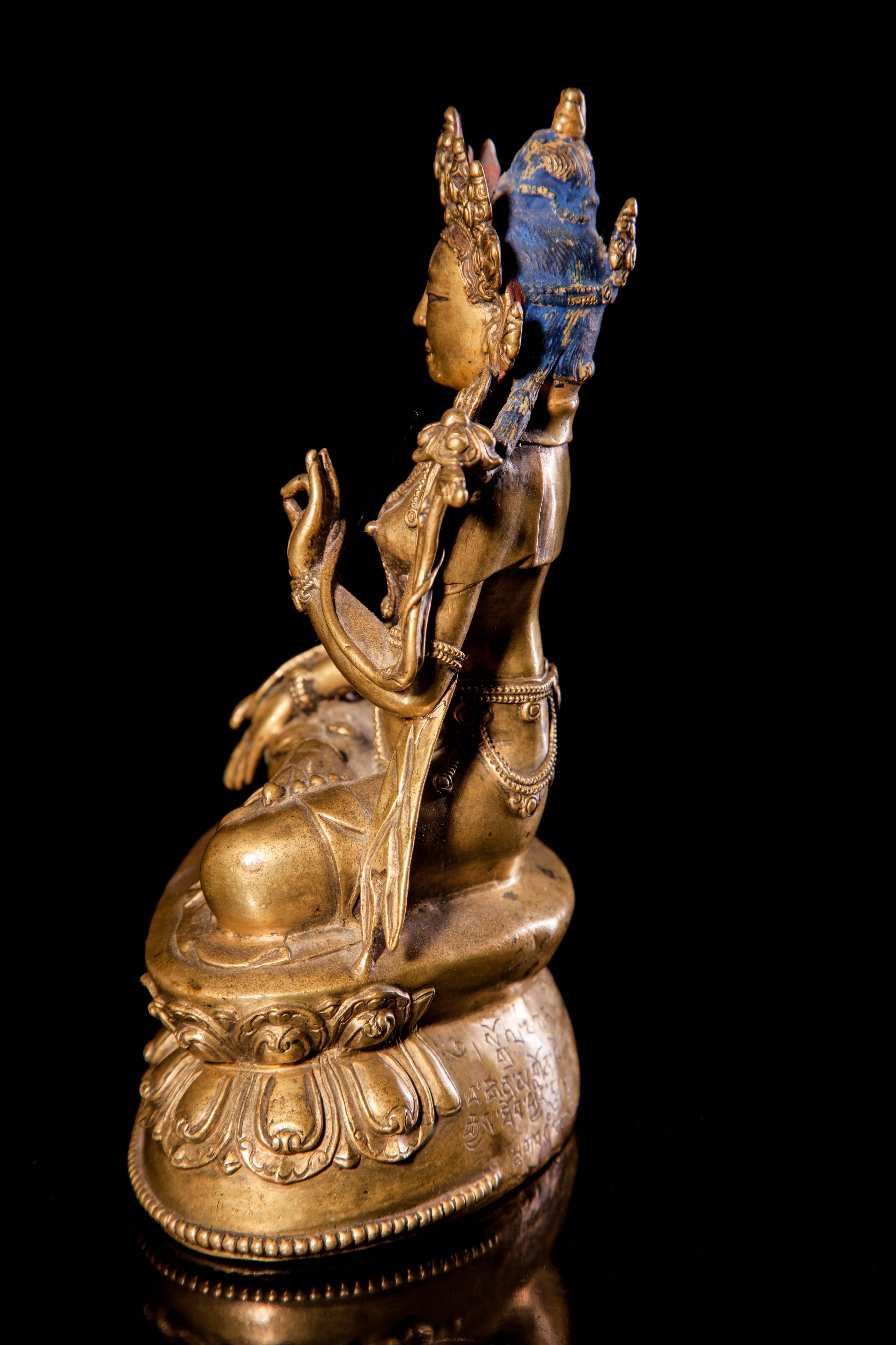 A bronze figure of White Tara,
Tibet, 15th century
Seated in dhyanasana on a double-lotus base, her left hand raised in vitarka mudra and her right lowered in varada mudra, each holding the stem of a lotus, wearing a flowing dhoti and beaded