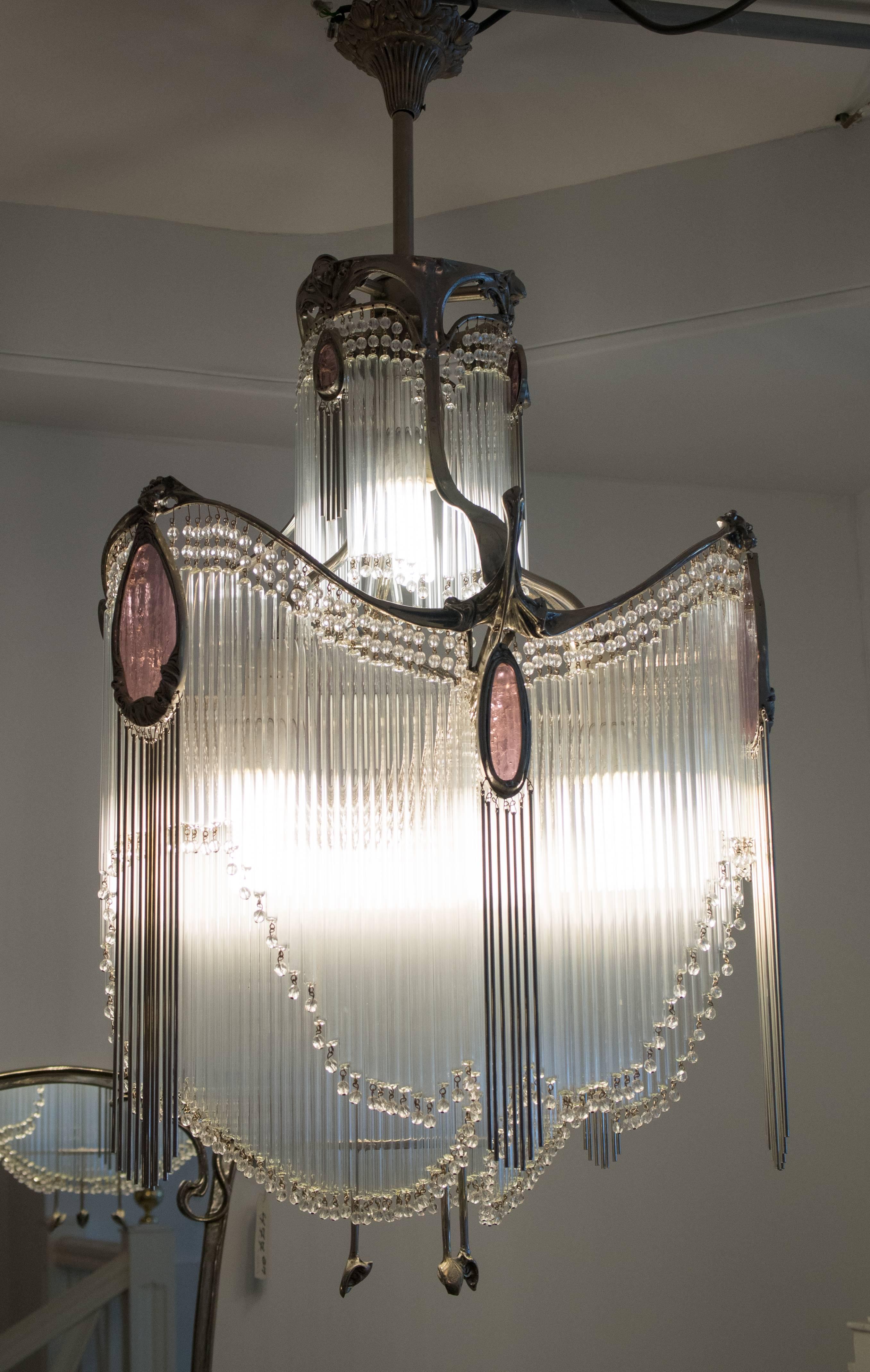 Art Nouveau bronze chandelier with nickel patinated finish and glass tubes.