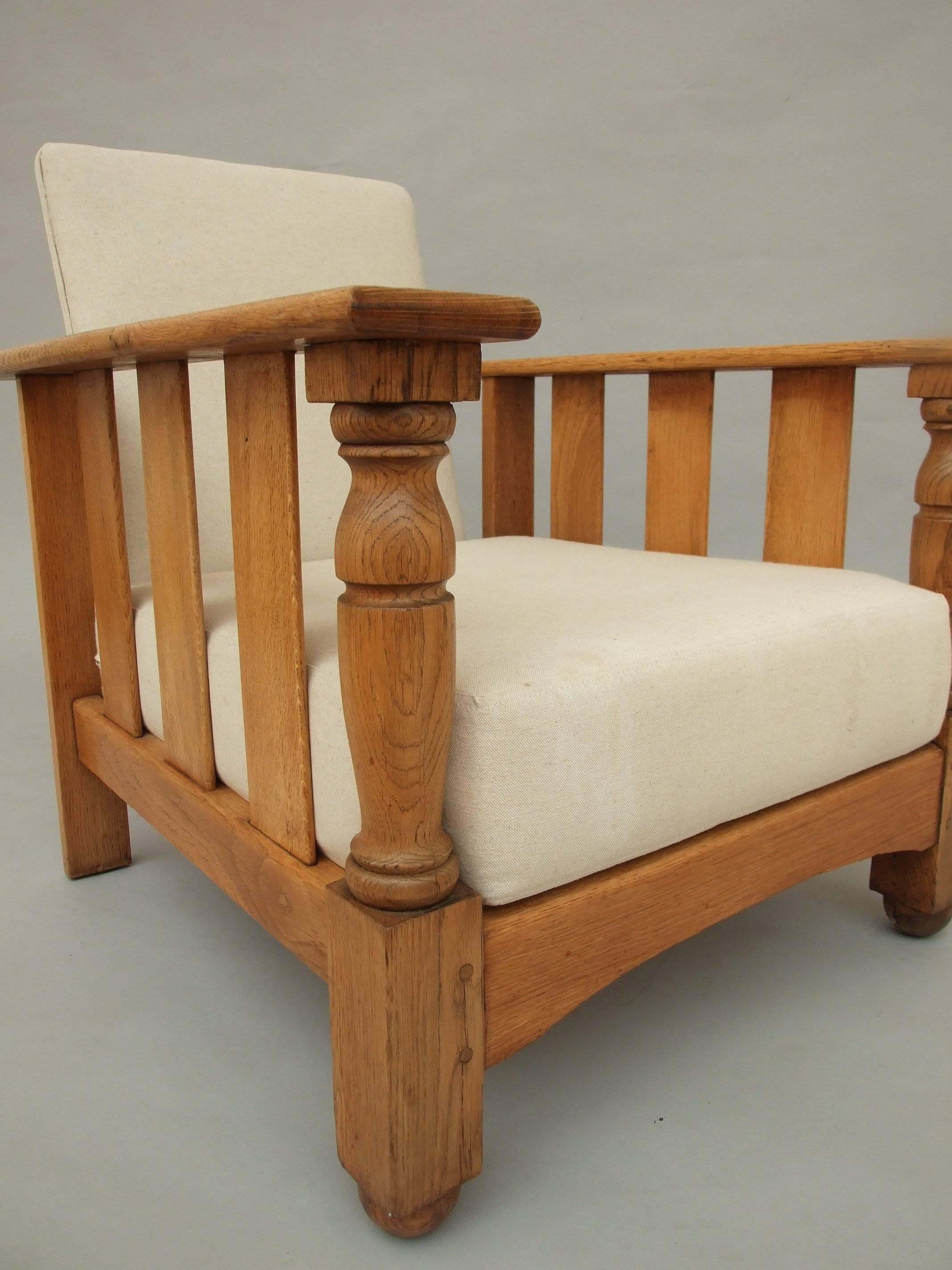 A pair of unusually large oak Arts & Crafts reclining armchairs with column fronts and slatted sides, new cushion seats, made by Furniture Industries Ercol, circa 1930, 74cm (29in) high, 70cm (27.5in) wide, 96cm (38in) deep. Luciano Ercolani