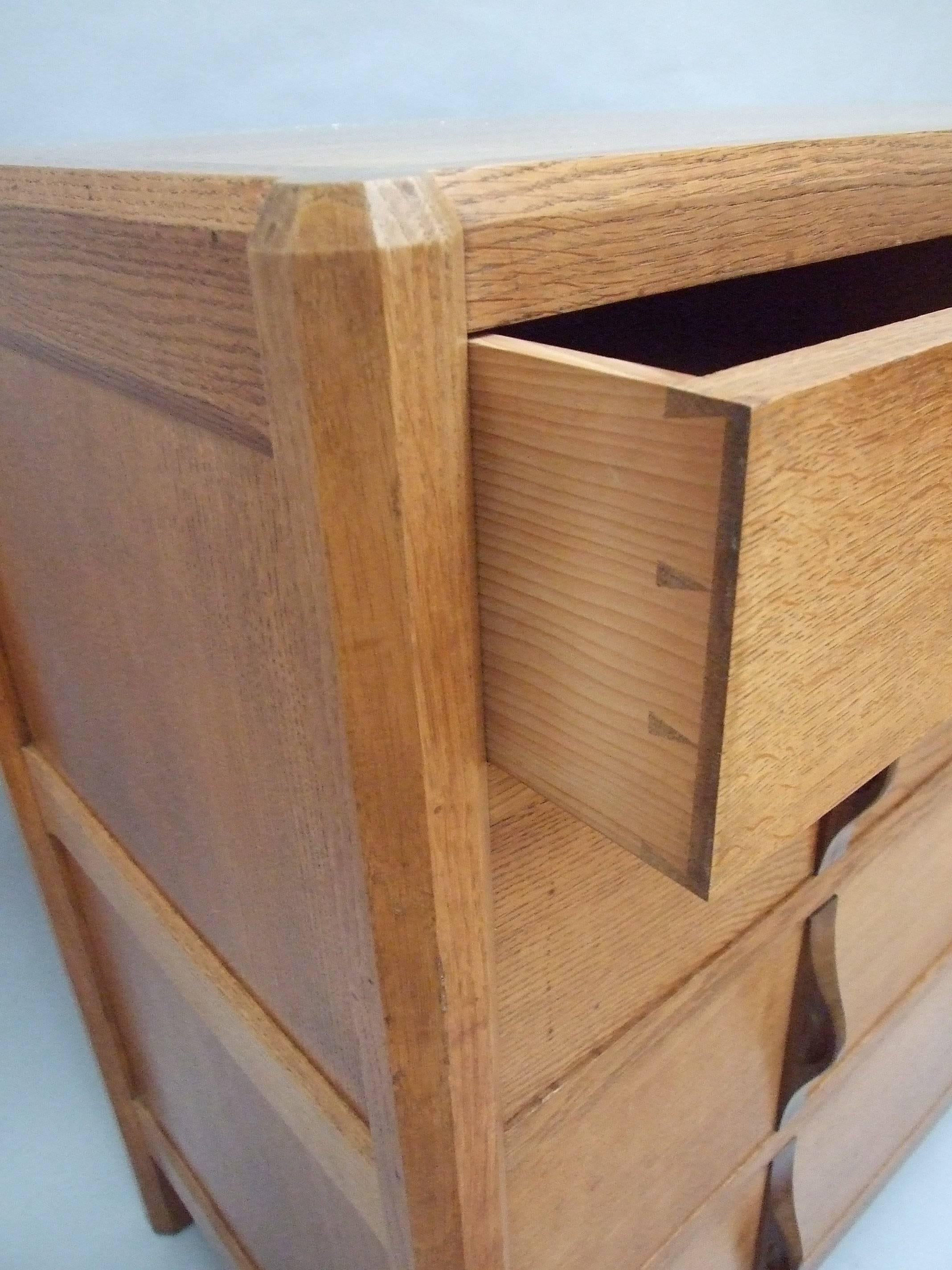 Gordon Russell a quarter sawn oak 'Stow' chest of drawers of two short drawers over three graduated long drawers with cedar linings, bog oak carved 'nip' handles, faceted stiles, chamfering to the frame, fielded panels and wedge tenons to the back,