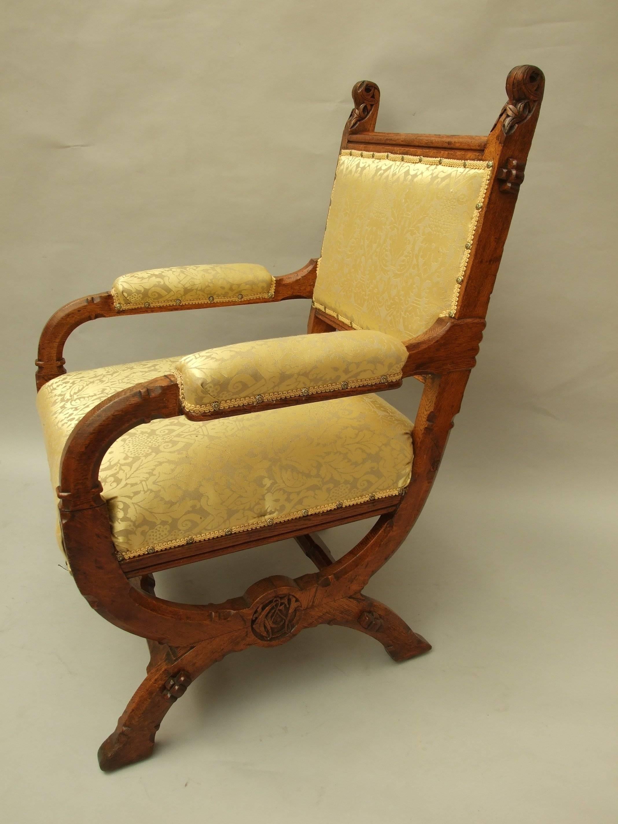 A W N Pugin: An important, oak Gothic reform armchair, chamfered all round, with tusked tenons construction, carved floret finials to the back, carved initials with roundels to the side cross-stretchers and inset brass castors, designed by A W N