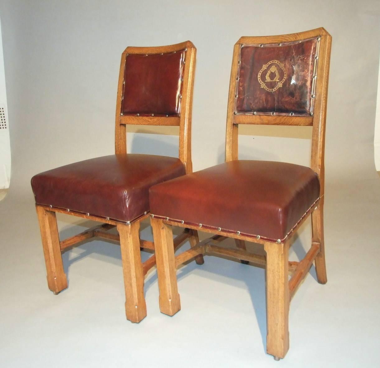 A set of nine Pugin house of commons style dining oak chairs upholstered in red leather, one with the original gold impressed Huddleston coat of arms, circa 1875. Measures: 36.5cm (93in) high.