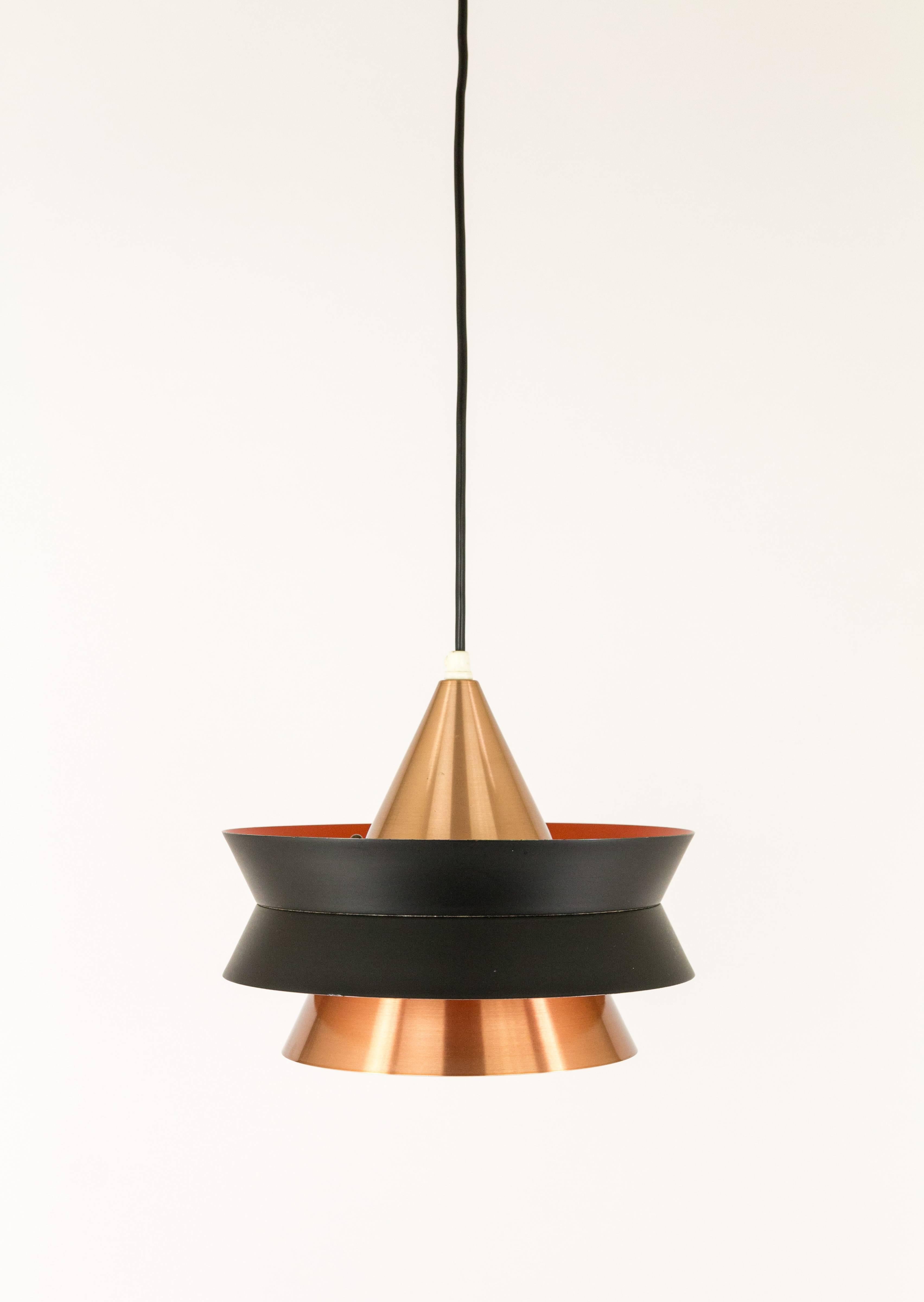 This cone-shaped pendant was designed by Carl Thore for Swedish lighting manufacturer Granhaga Metallindustri.

The cone of solid copper consists of two parts and is held together by a black lacquered metal ring. The orange and white coatings on the