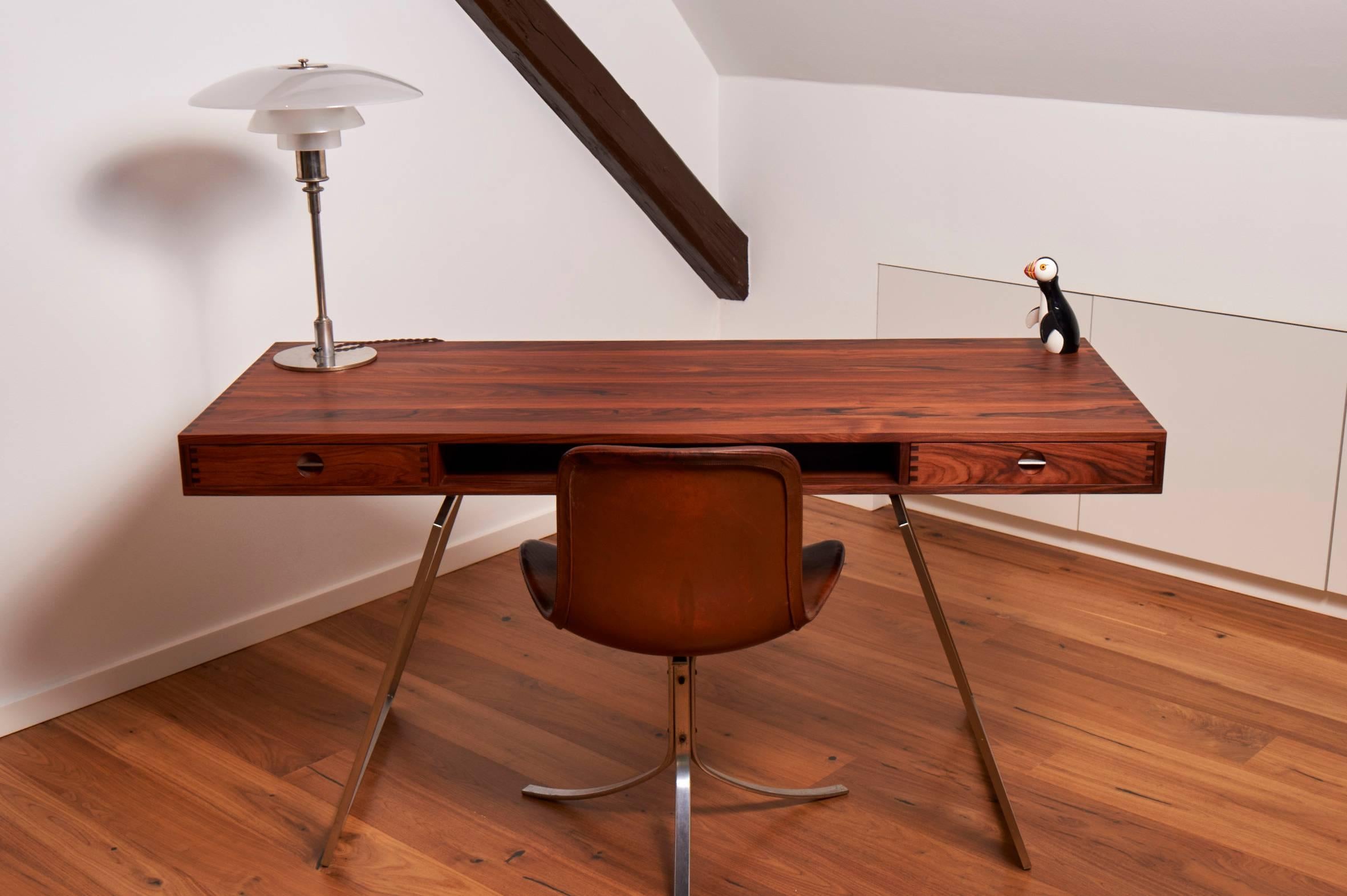 Desk in rosewood with a steel frame.

The desk is made with a lot of beautiful details. 
There is only one of these models in rosewood.