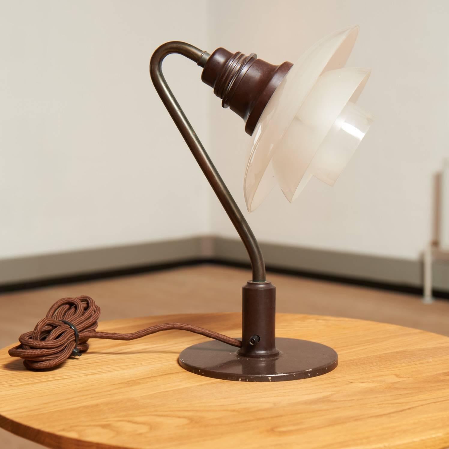 The low model of Poul Henningsens table lamp Snowdrop, PH 2/2. 
100% original from the 1930s with browned brass, screens in one layer mat glass and with the old circuit breaker.
The PH lamp is stamped 