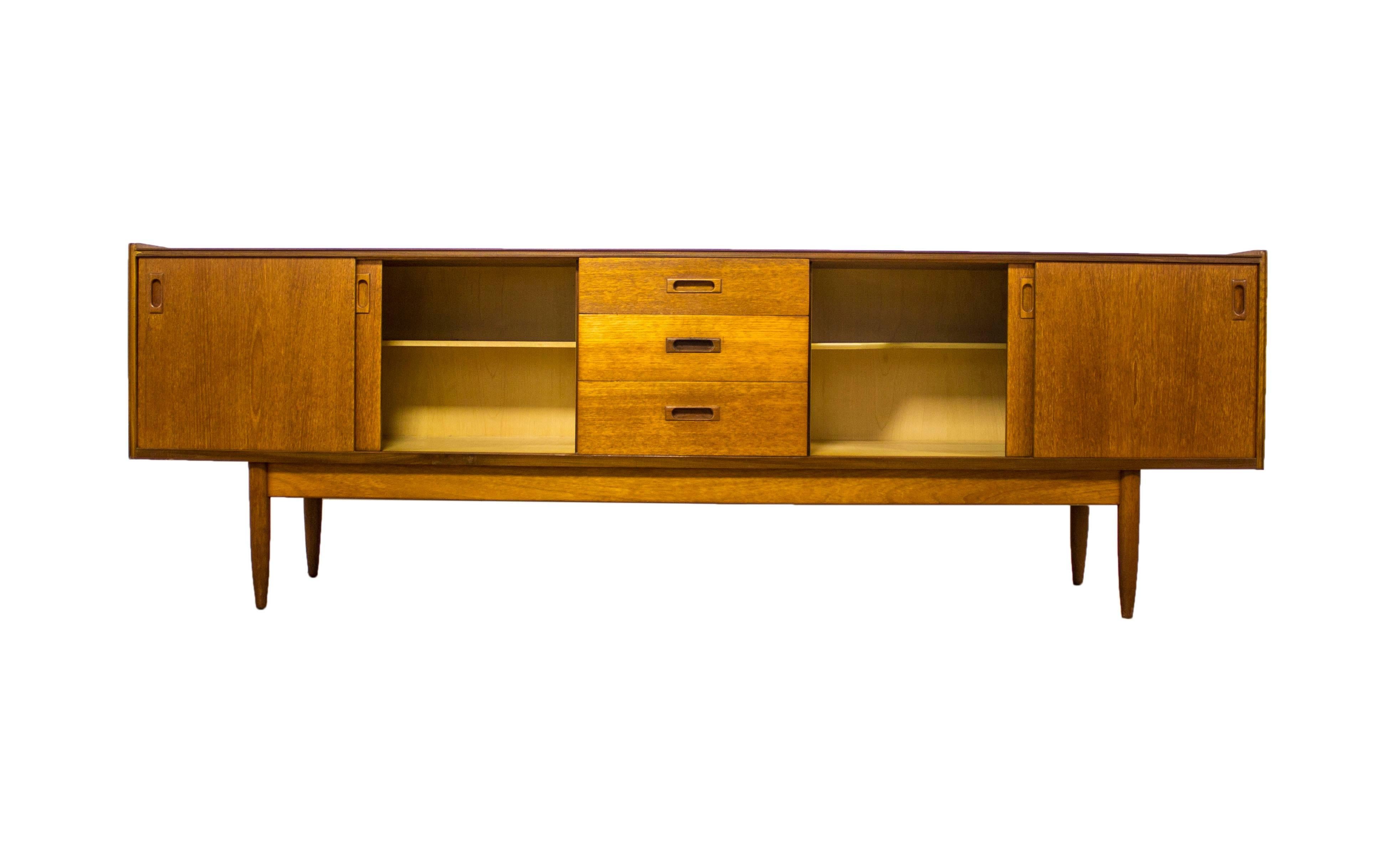 The Danish designers of the Mid-Century movement brought clean, simple lines to the masses and introduced the world to the wonders of teak in it’s many guises, stunning grain and rich colors.
This beautiful and rich sideboard features ample storage