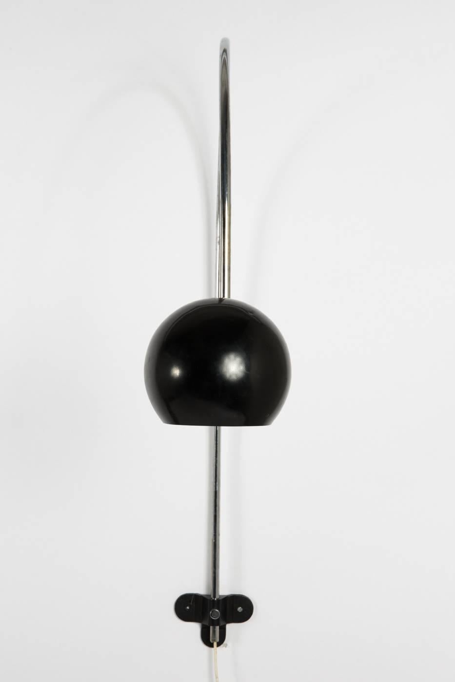 Large bow lamp in black and chrome lacquered metal, large lamp, ball-shaped lamp head on long curved metal tube, head and arms adjustable in height, mounting with clover-shaped fixture.
 