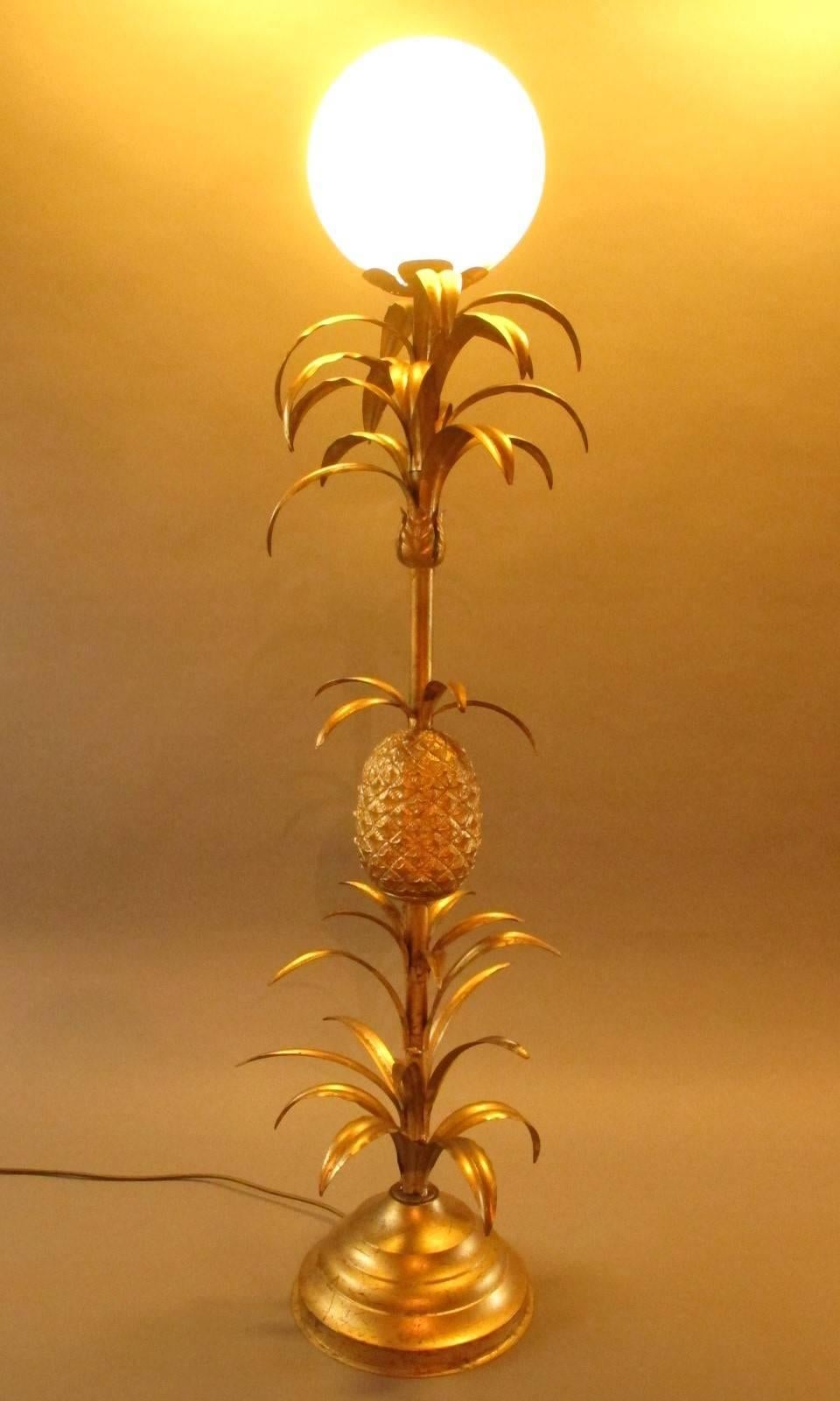 Mid-20th century palm lamp with pineapple from the 1960s. In brass, with fine painted metal leaves and a big pineapple. On the top a big white frosted glass globe.